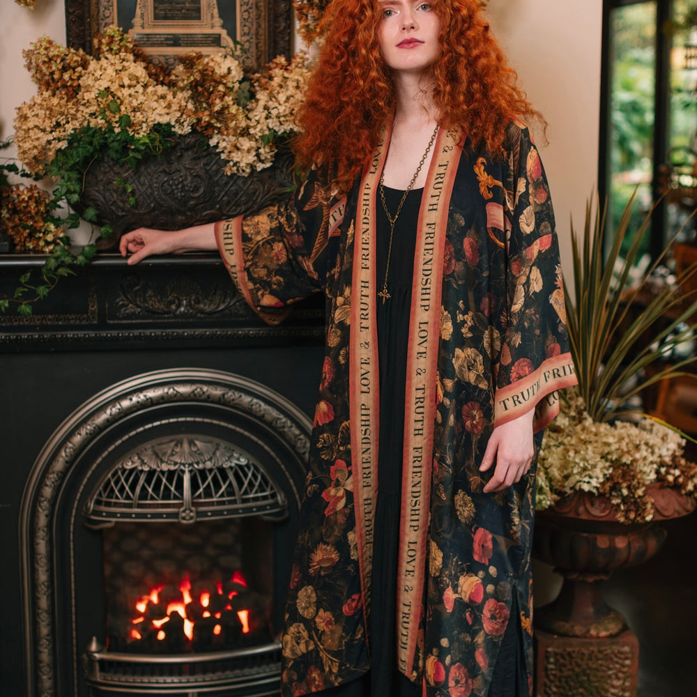 
                  
                    Model wearing a full-length bamboo-viscose duster featuring a collage of antique artwork with romance, loyalty, and old-world beauty - Market of Stars
                  
                