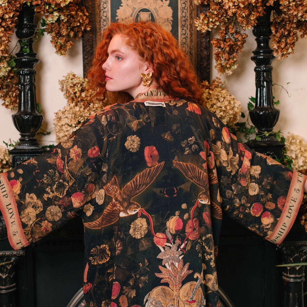 Model wearing a full-length bamboo-viscose duster featuring a collage of antique artwork with romance, loyalty, and old-world beauty - Market of Stars