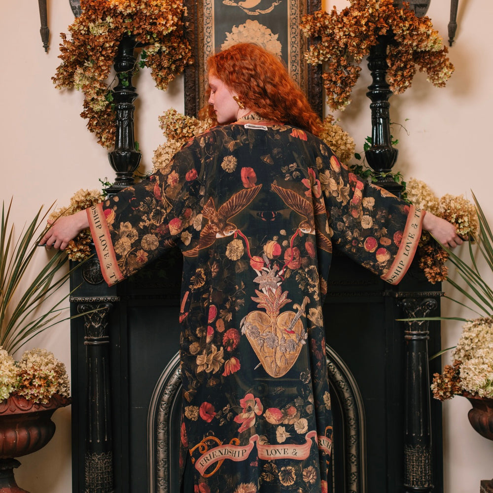 Model wearing a full-length bamboo-viscose duster featuring a collage of antique artwork with romance, loyalty, and old-world beauty - Market of Stars