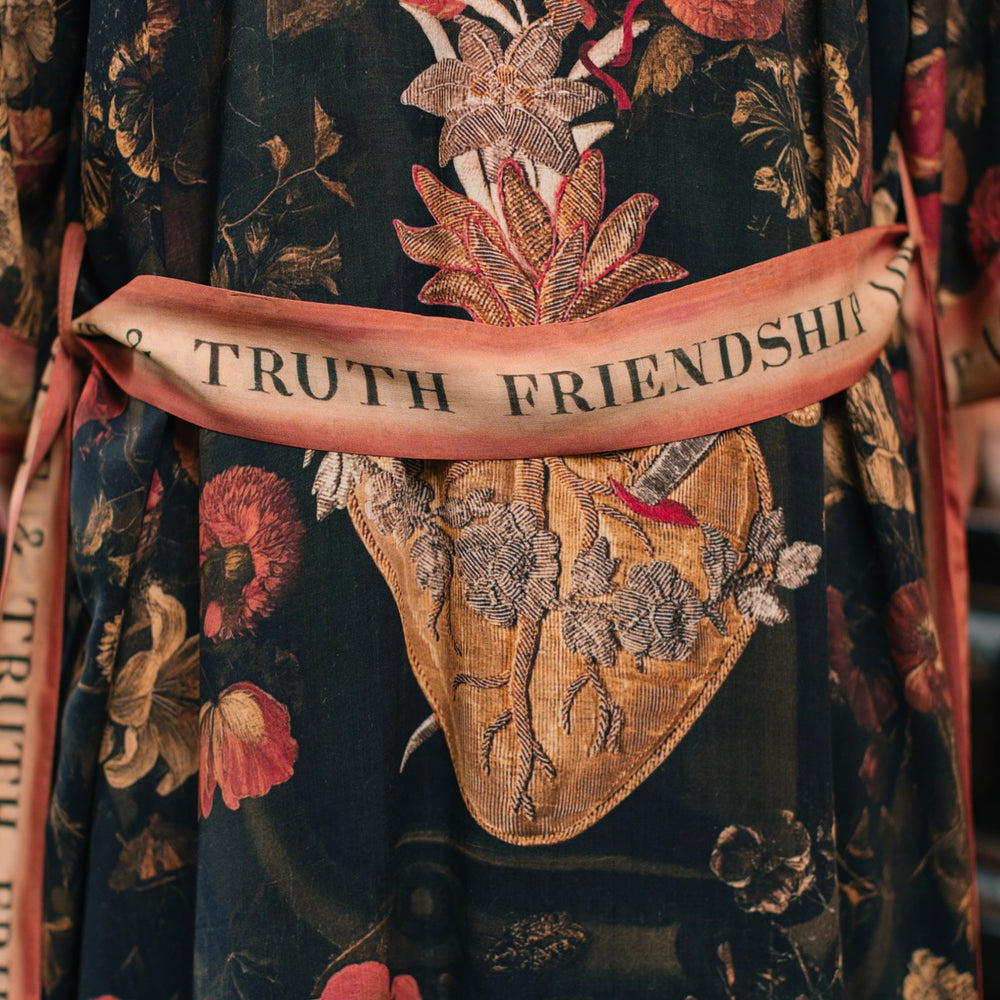 
                  
                    Model wearing a full-length bamboo-viscose duster featuring a collage of antique artwork with romance, loyalty, and old-world beauty - Market of Stars
                  
                