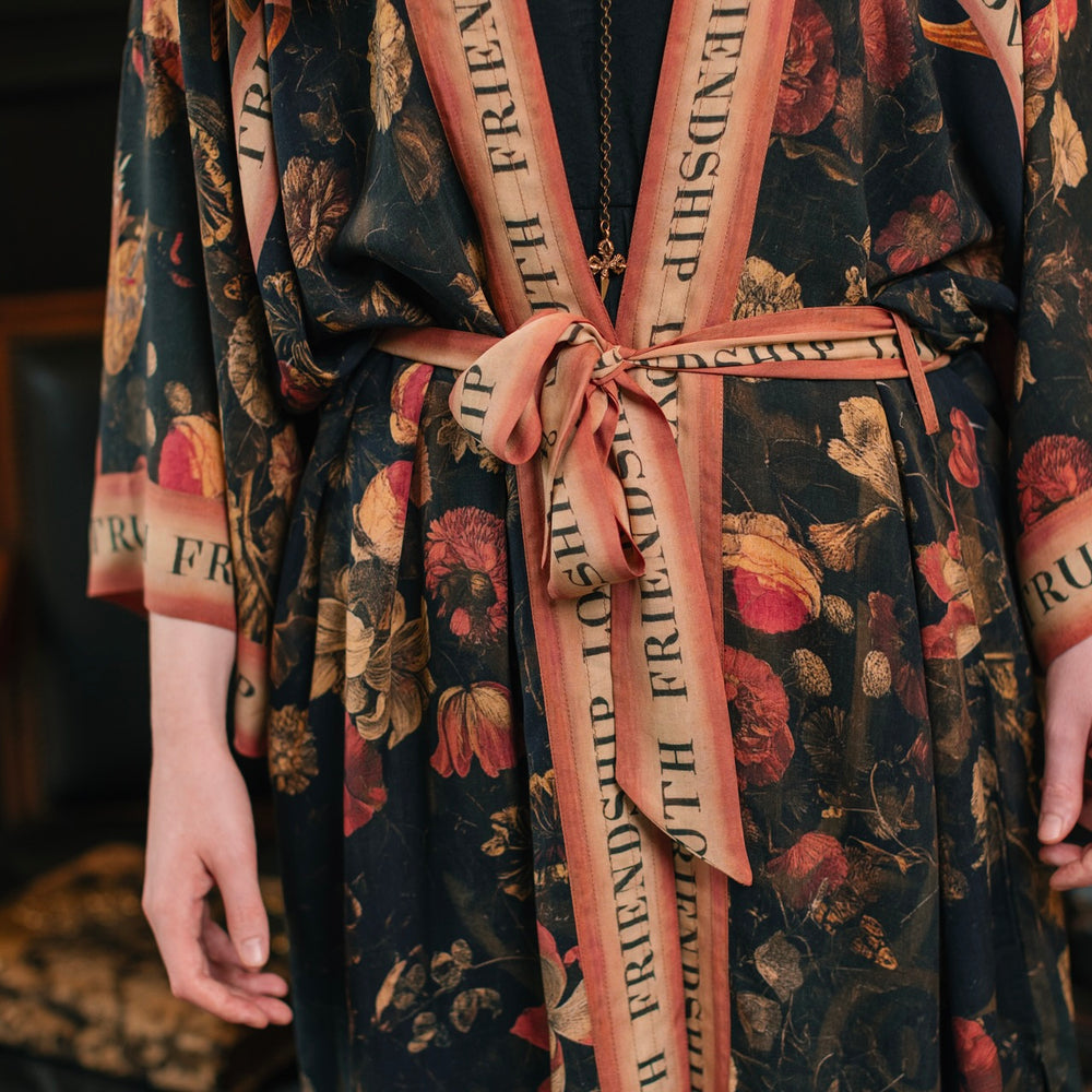 
                  
                    Model wearing a full-length bamboo-viscose duster featuring a collage of antique artwork with romance, loyalty, and old-world beauty - Market of Stars
                  
                