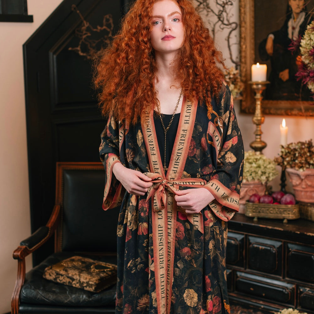 
                  
                    Model wearing a full-length bamboo-viscose duster featuring a collage of antique artwork with romance, loyalty, and old-world beauty - Market of Stars
                  
                