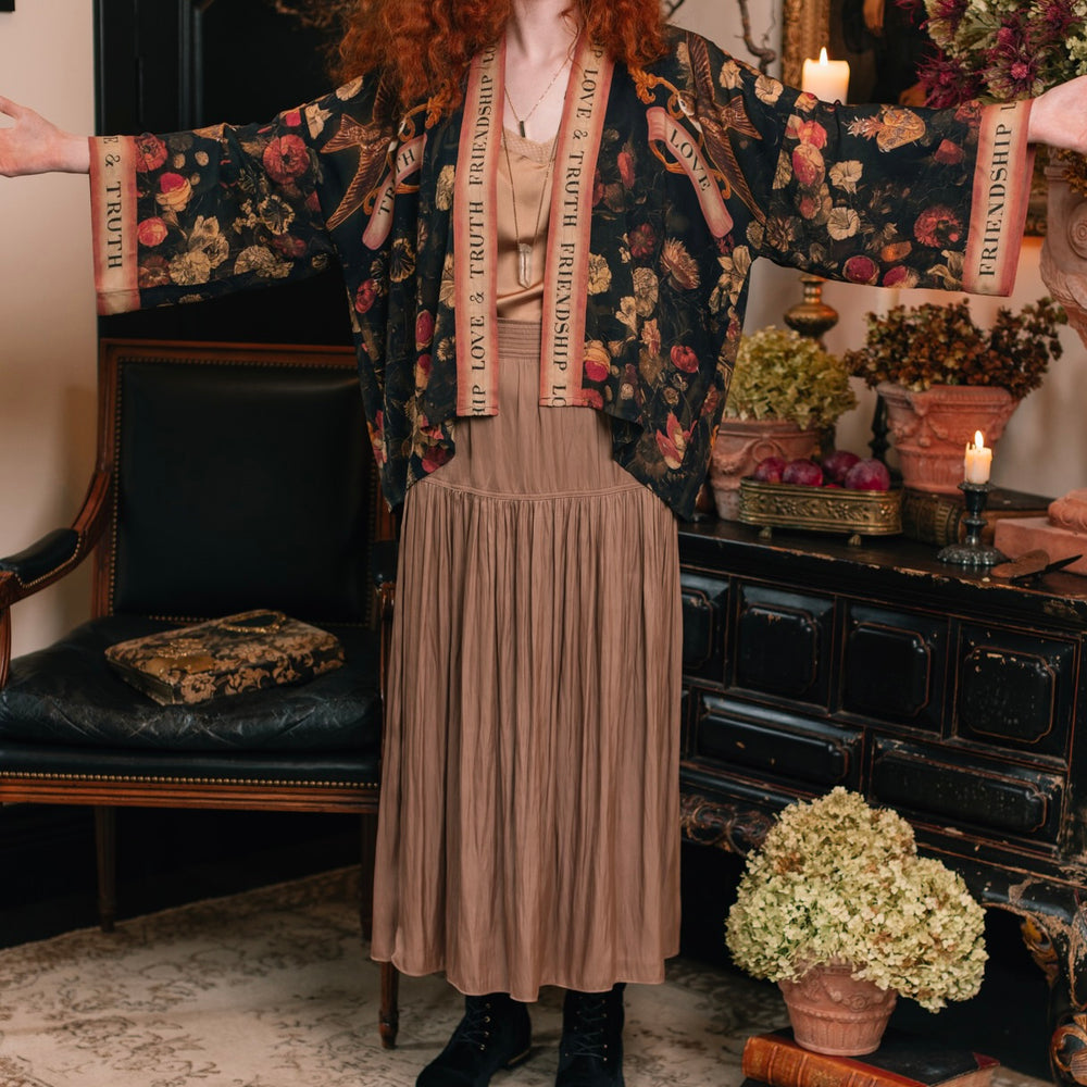 
                  
                    Model wearing a cropped-length bamboo-viscose duster featuring a collage of antique artwork with romance, loyalty, and old-world beauty - Market of Stars
                  
                