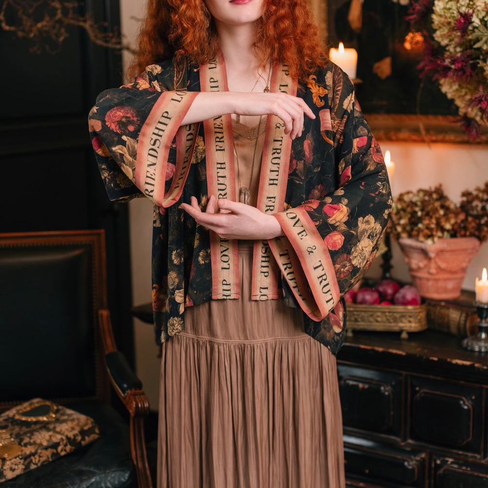 
                  
                    Model wearing a cropped-length bamboo-viscose duster featuring a collage of antique artwork with romance, loyalty, and old-world beauty - Market of Stars
                  
                