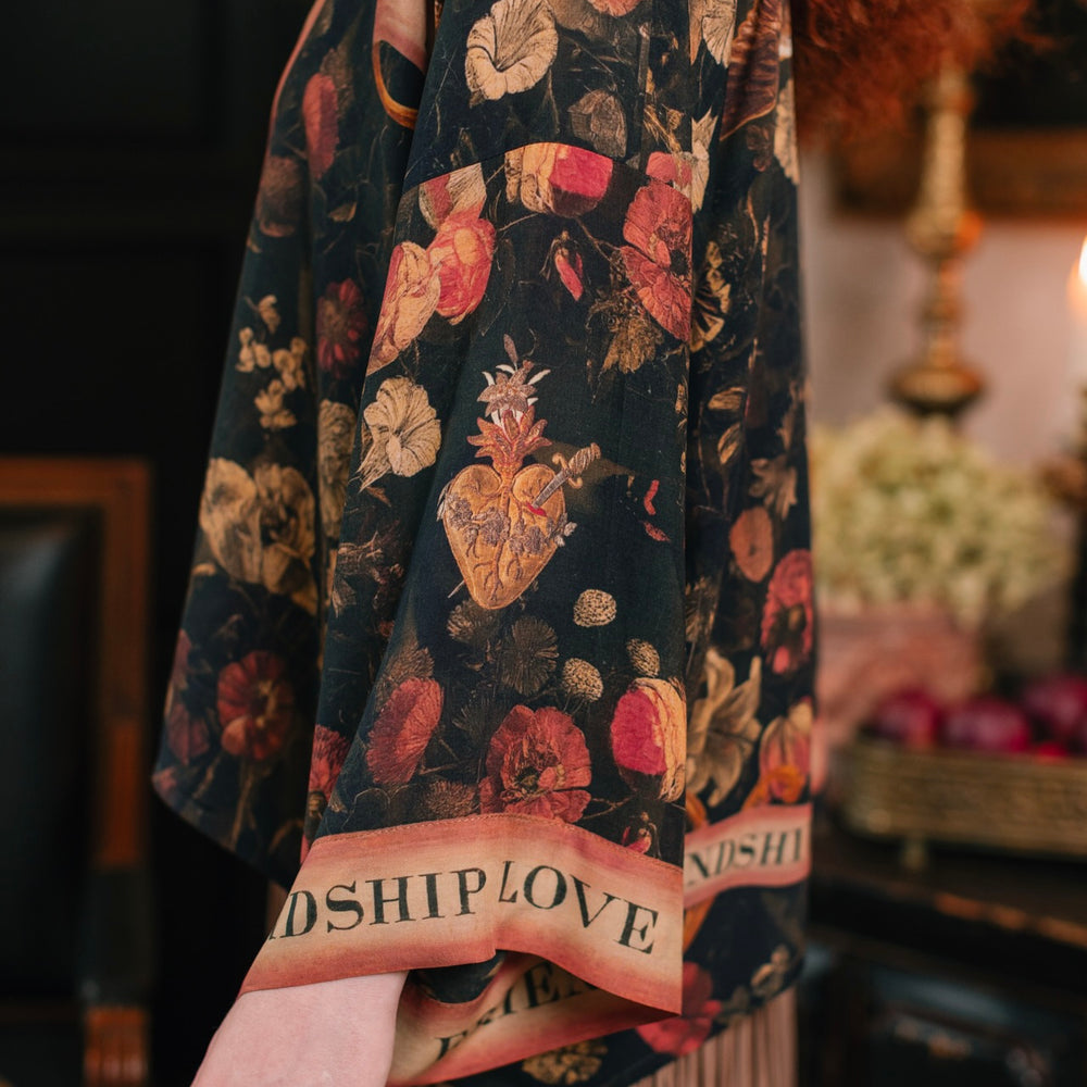 
                  
                    Model wearing a cropped-length bamboo-viscose duster featuring a collage of antique artwork with romance, loyalty, and old-world beauty - Market of Stars
                  
                