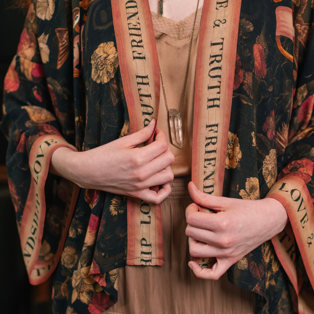 
                  
                    Model wearing a cropped-length bamboo-viscose duster featuring a collage of antique artwork with romance, loyalty, and old-world beauty - Market of Stars
                  
                