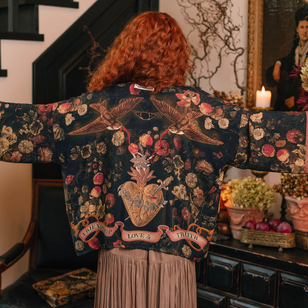 
                  
                    Model wearing a cropped-length bamboo-viscose duster featuring a collage of antique artwork with romance, loyalty, and old-world beauty - Market of Stars
                  
                