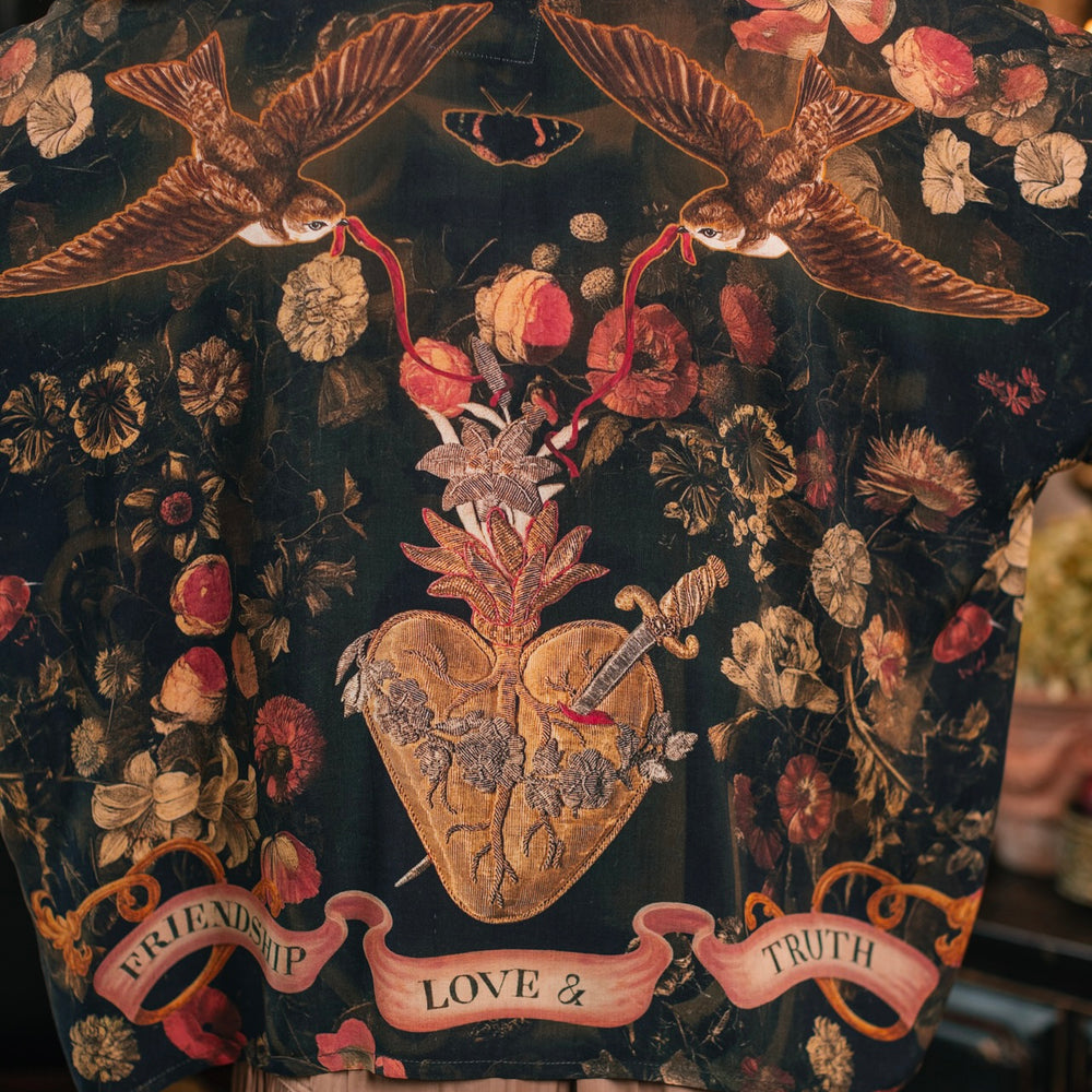 
                  
                    Model wearing a cropped-length bamboo-viscose duster featuring a collage of antique artwork with romance, loyalty, and old-world beauty - Market of Stars
                  
                