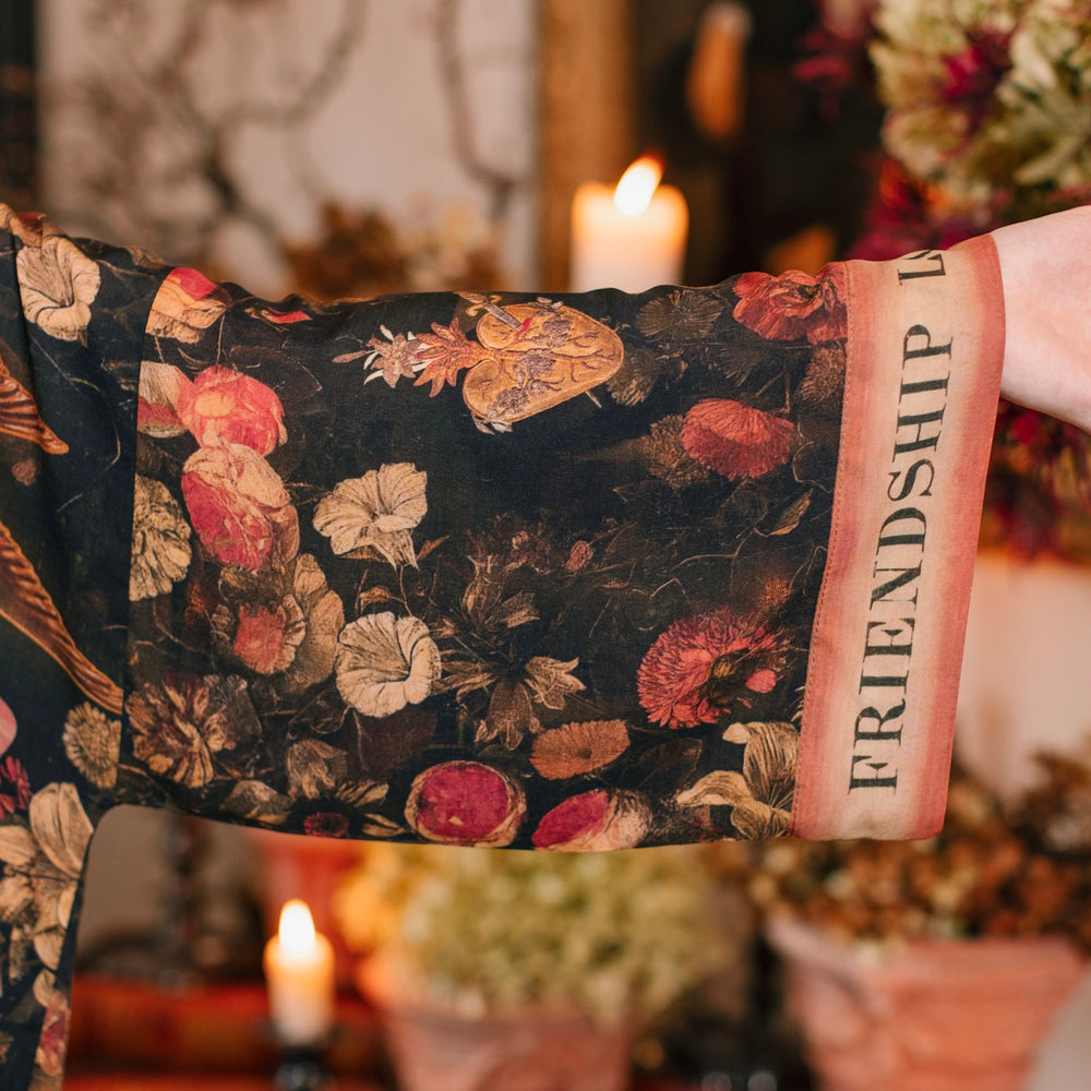 
                  
                    Model wearing a cropped-length bamboo-viscose duster featuring a collage of antique artwork with romance, loyalty, and old-world beauty - Market of Stars
                  
                