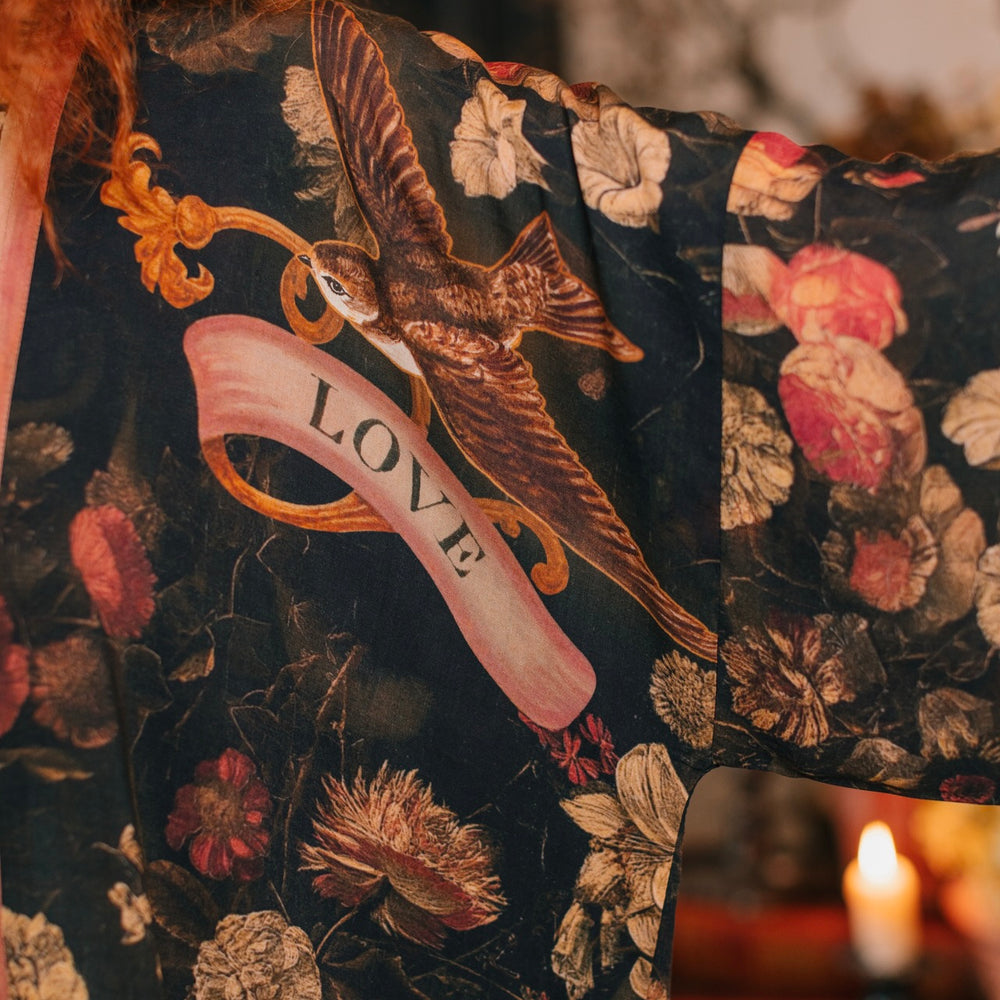 
                  
                    Model wearing a cropped-length bamboo-viscose duster featuring a collage of antique artwork with romance, loyalty, and old-world beauty - Market of Stars
                  
                