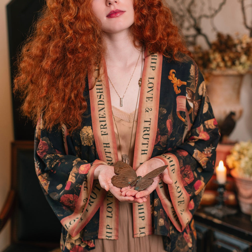 
                  
                    Model wearing a cropped-length bamboo-viscose duster featuring a collage of antique artwork with romance, loyalty, and old-world beauty - Market of Stars
                  
                