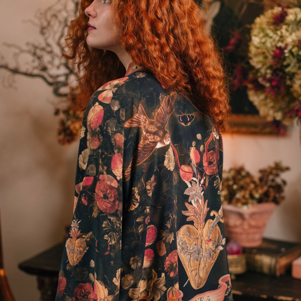 
                  
                    Model wearing a cropped-length bamboo-viscose duster featuring a collage of antique artwork with romance, loyalty, and old-world beauty - Market of Stars
                  
                