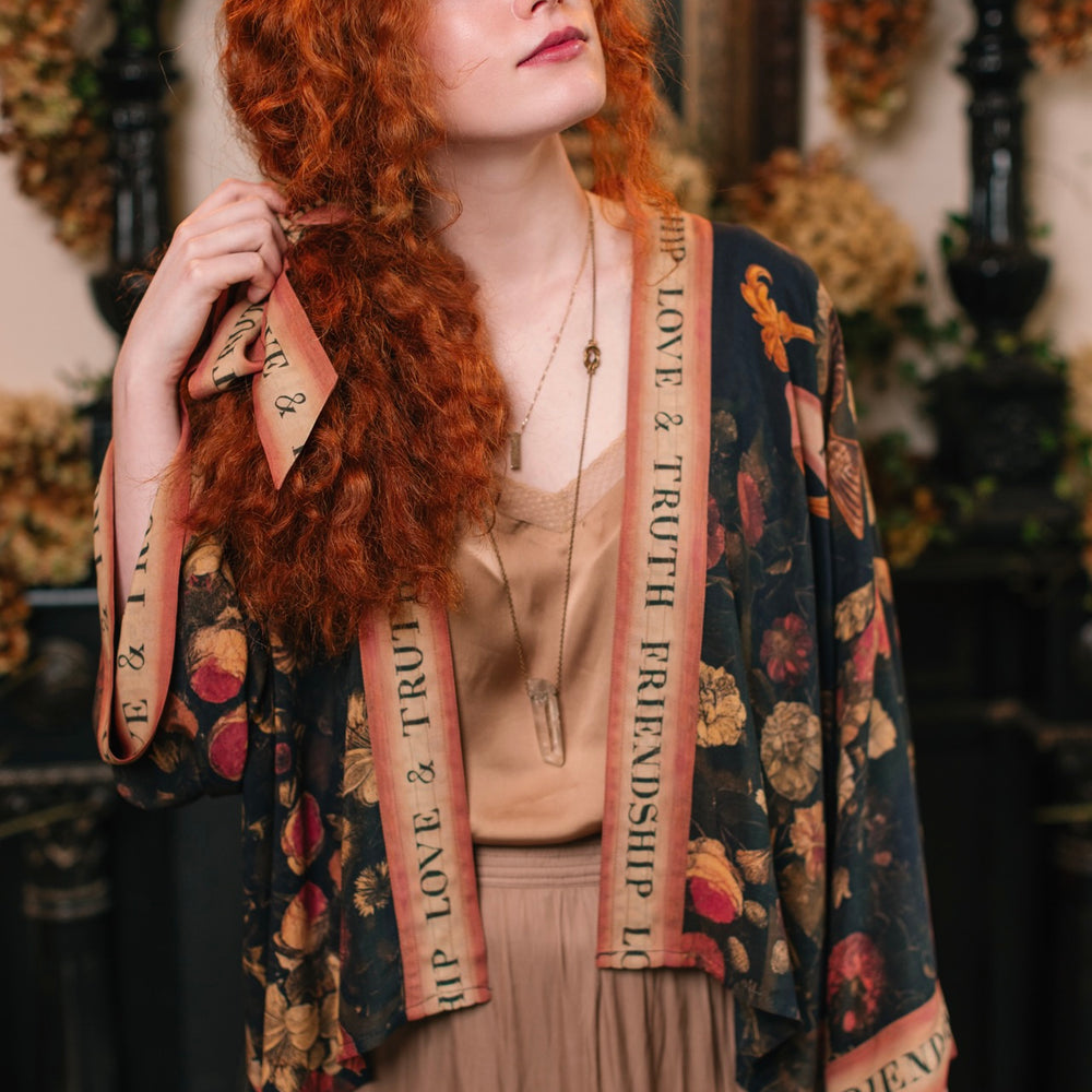 
                  
                    Model wearing a cropped-length bamboo-viscose duster featuring a collage of antique artwork with romance, loyalty, and old-world beauty - Market of Stars
                  
                