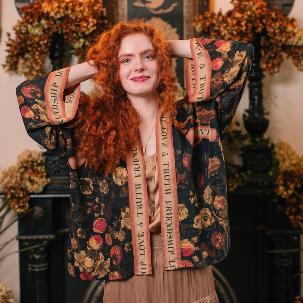 
                  
                    Model wearing a cropped-length bamboo-viscose duster featuring a collage of antique artwork with romance, loyalty, and old-world beauty - Market of Stars
                  
                