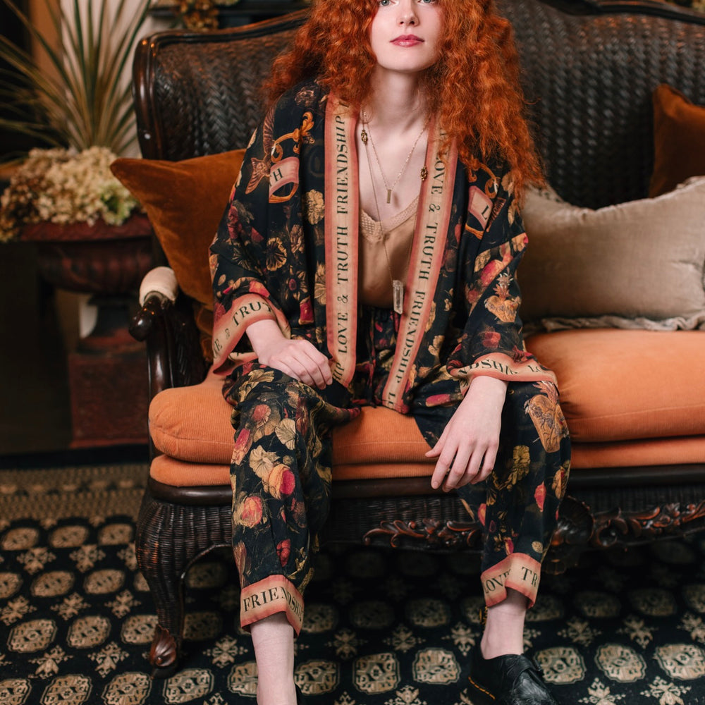 
                  
                    Model wearing a cropped-length bamboo-viscose duster featuring a collage of antique artwork with romance, loyalty, and old-world beauty - Market of Stars
                  
                