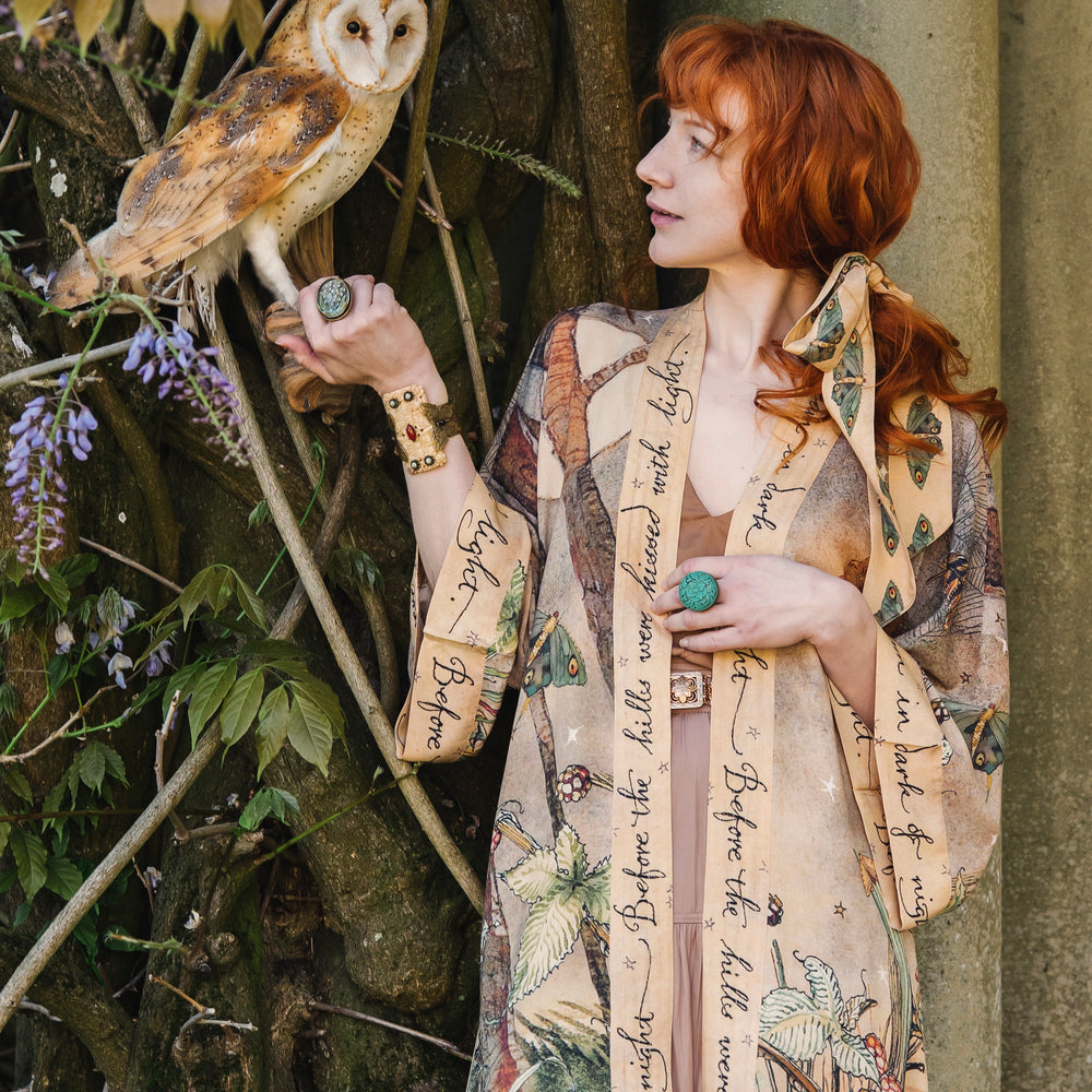 Model wearing an enchanting kimono duster robe featuring illustrations by Charles van Sandwyck's, crafted from airy bamboo-based viscose with a touch of whimsical magic - Market of Stars