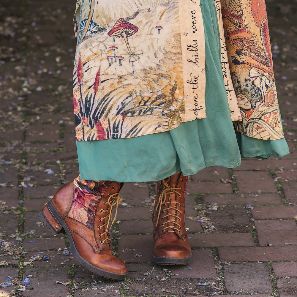 
                  
                    Model wearing an enchanting kimono duster robe featuring illustrations by Charles van Sandwyck's, crafted from airy bamboo-based viscose with a touch of whimsical magic - Market of Stars
                  
                