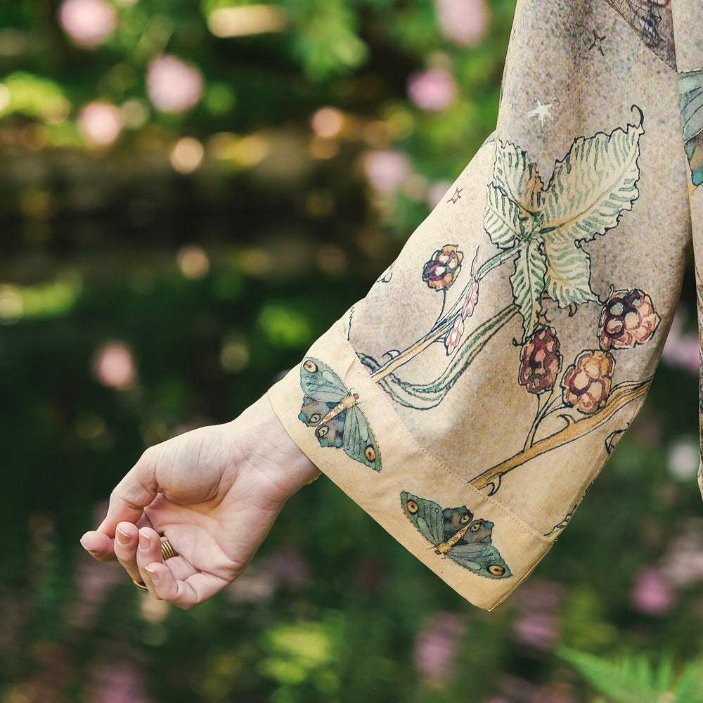 
                  
                    Model wearing an enchanting cropped kimono duster featuring illustrations by Charles van Sandwyck's, crafted from airy bamboo-based viscose with a touch of whimsical magic - Market of Stars
                  
                