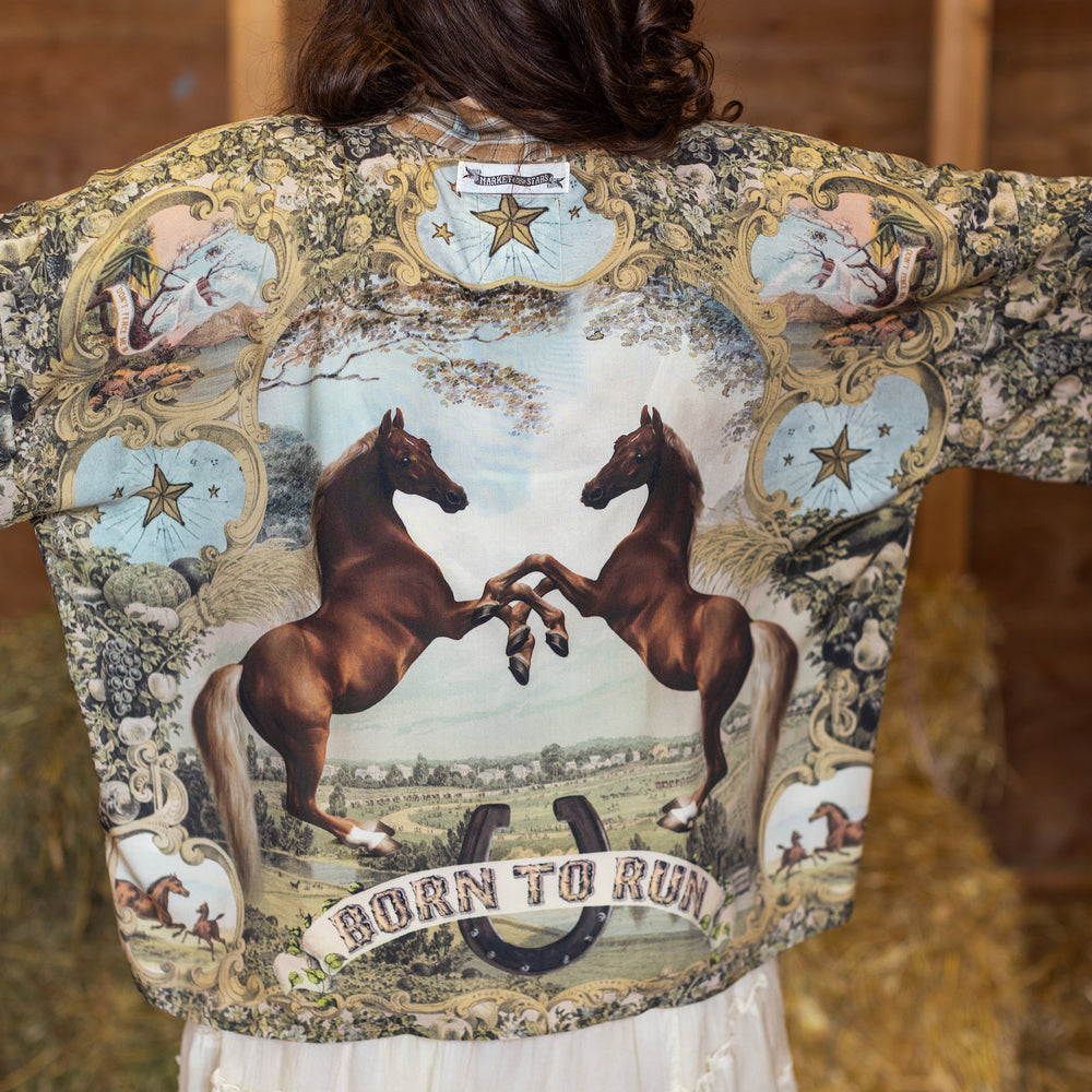 
                  
                    Model wearing a bamboo-viscose cropped kimono duster made for everyday adventures with a whimsical print celebrating one's unbridled spirit of adventure - Market of Stars
                  
                