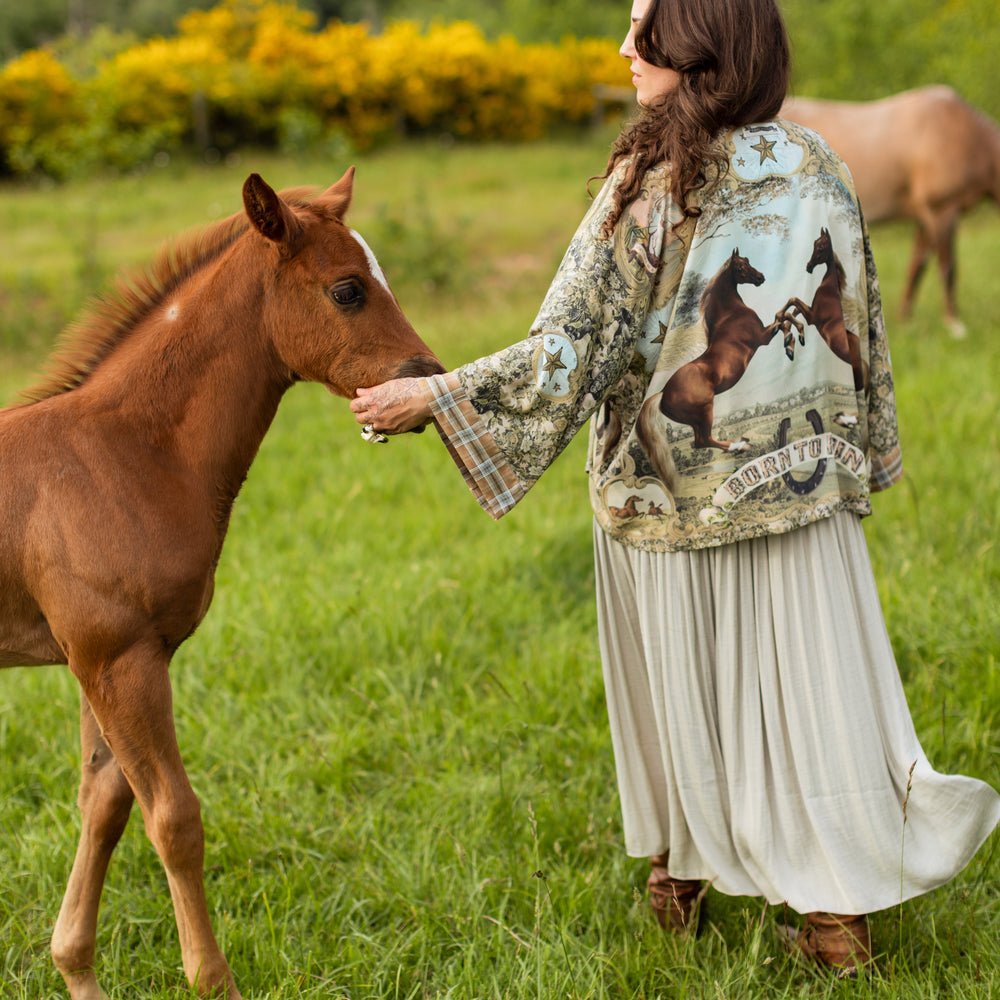 
                  
                    Model wearing a bamboo-viscose cropped kimono duster made for everyday adventures with a whimsical print celebrating one's unbridled spirit of adventure - Market of Stars
                  
                