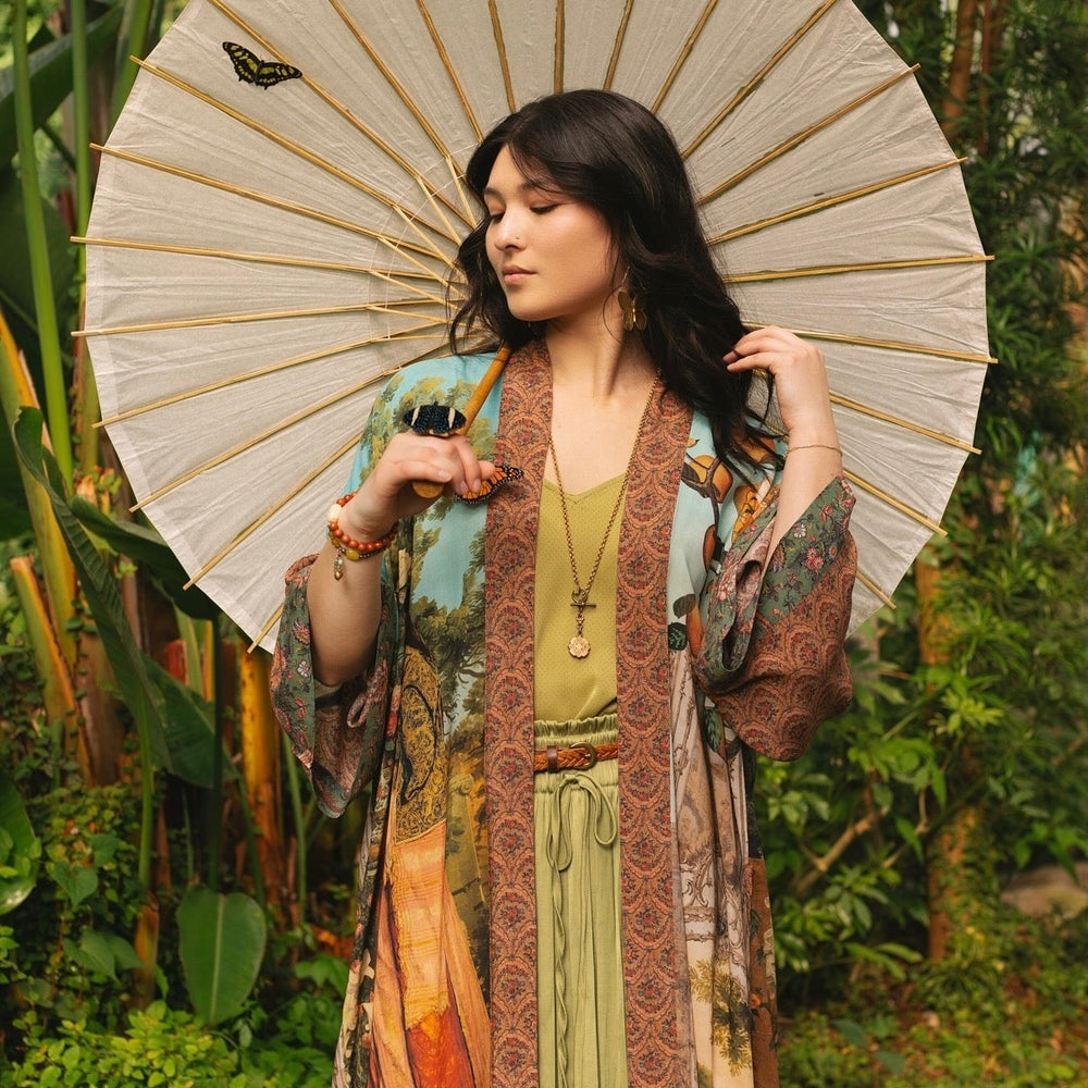 
                  
                    Model wearing Peace, Wine & Sunshine Bohéme Slip Dress featuring botanical collages and playful peace, wine and sunshine lettering on the hem – Market of Stars.
                  
                