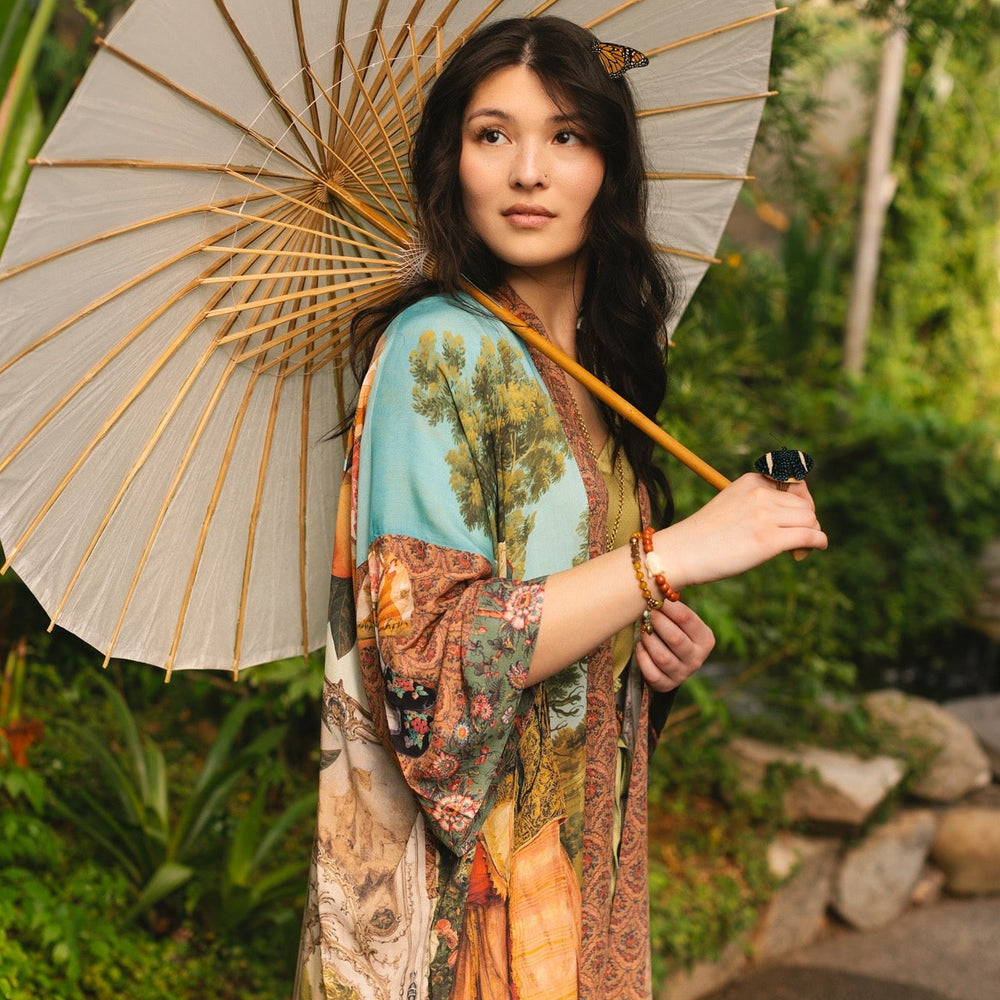 
                  
                    Model wearing Peace, Wine & Sunshine Bohéme Slip Dress featuring botanical collages and playful peace, wine and sunshine lettering on the hem – Market of Stars.
                  
                