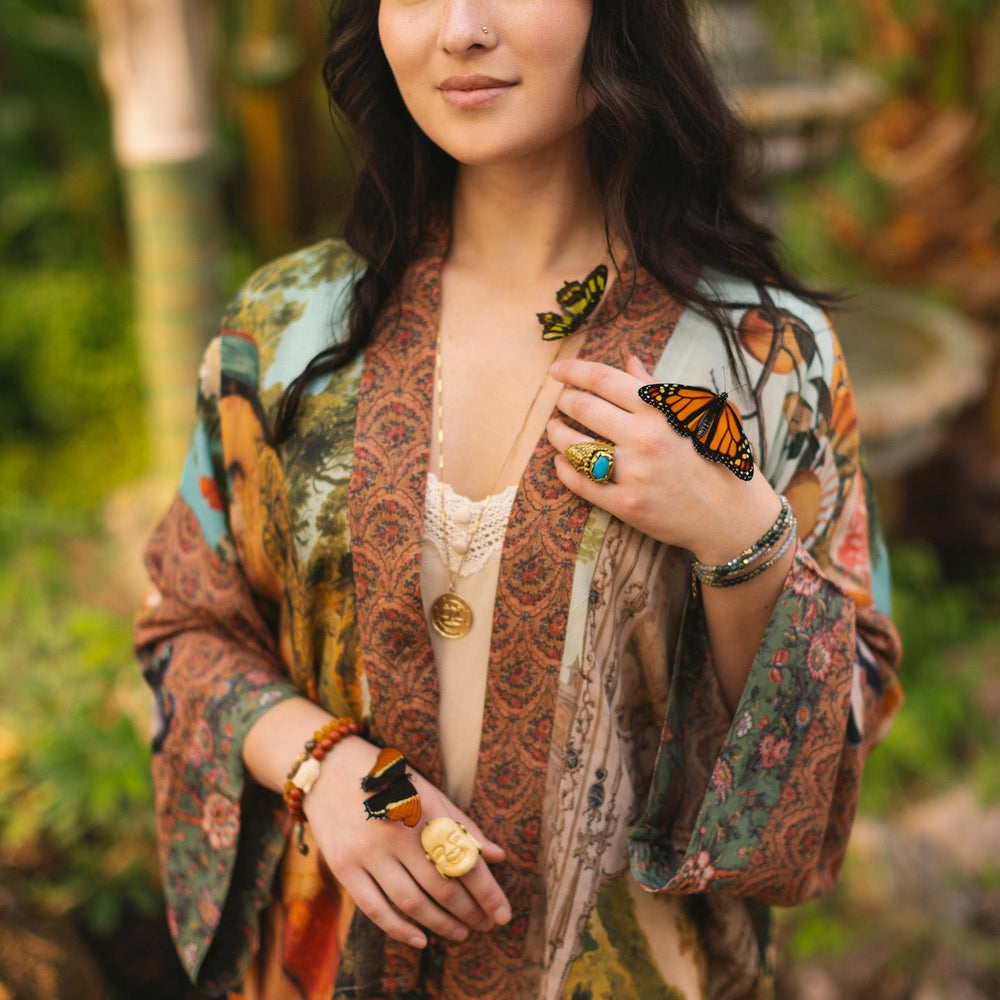 
                  
                    Model wearing Peace, Wine & Sunshine Bohéme Slip Dress featuring botanical collages and playful peace, wine and sunshine lettering on the hem – Market of Stars.
                  
                