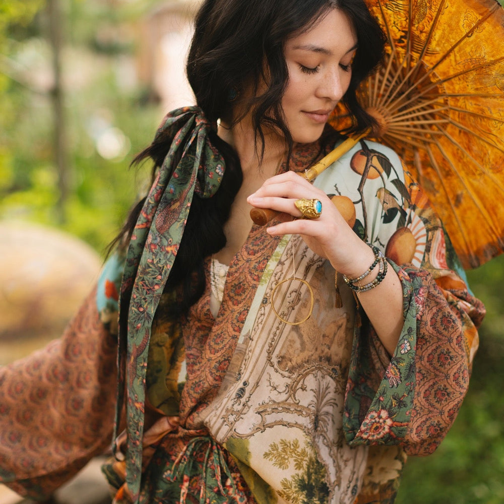 
                  
                    Model wearing Peace, Wine & Sunshine Bohéme Slip Dress featuring botanical collages and playful peace, wine and sunshine lettering on the hem – Market of Stars.
                  
                