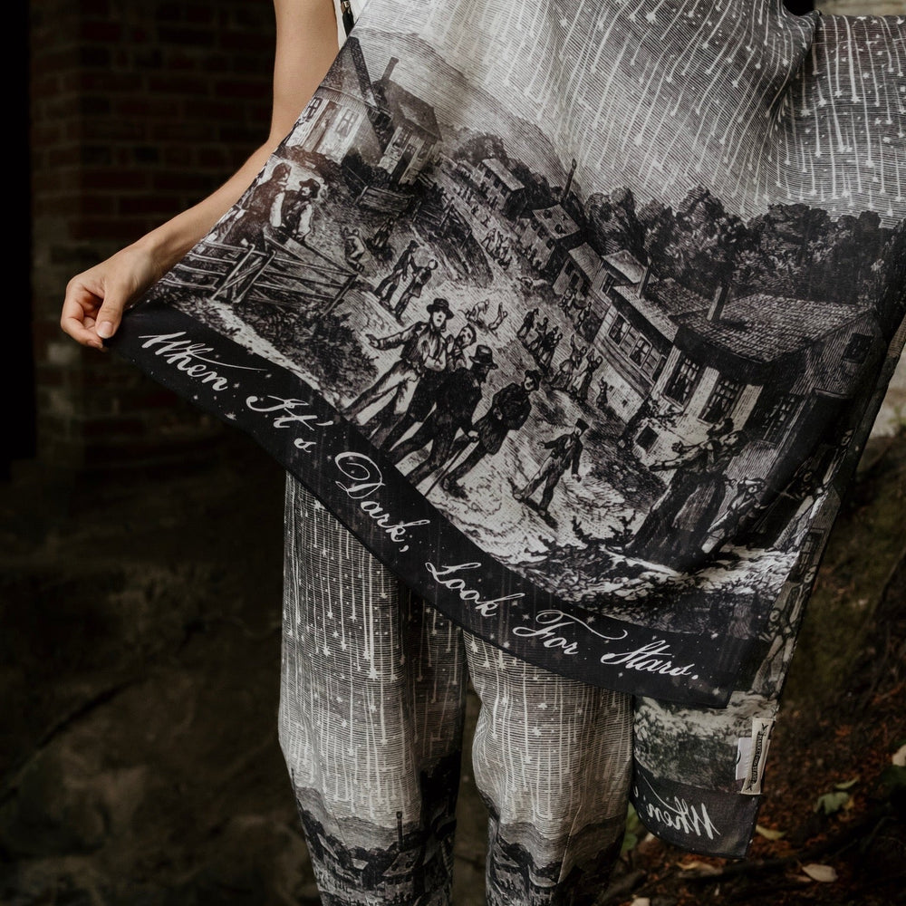 
                  
                    Model wearing the Stargazer Scarf featuring antique night sky illustrations and the quote "When it's dark, look for stars" – Market of Stars
                  
                