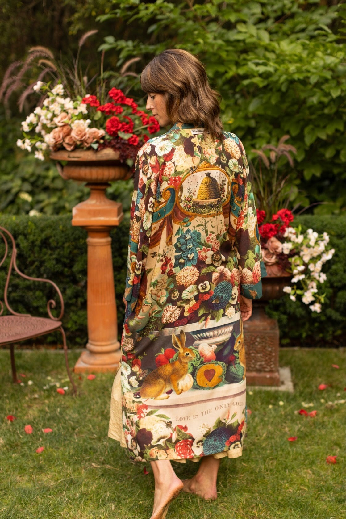 Model wearing Stay Gold Opera Duster with wildflower, bee, and bunny rabbit illustrations, golden script, and vintage collage in full-length kimono silhouette – Market of Stars