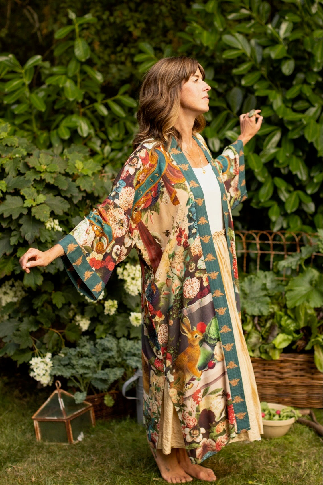 Model wearing Stay Gold Opera Duster with wildflower, bee, and bunny rabbit illustrations, golden script, and vintage collage in full-length kimono silhouette – Market of Stars
