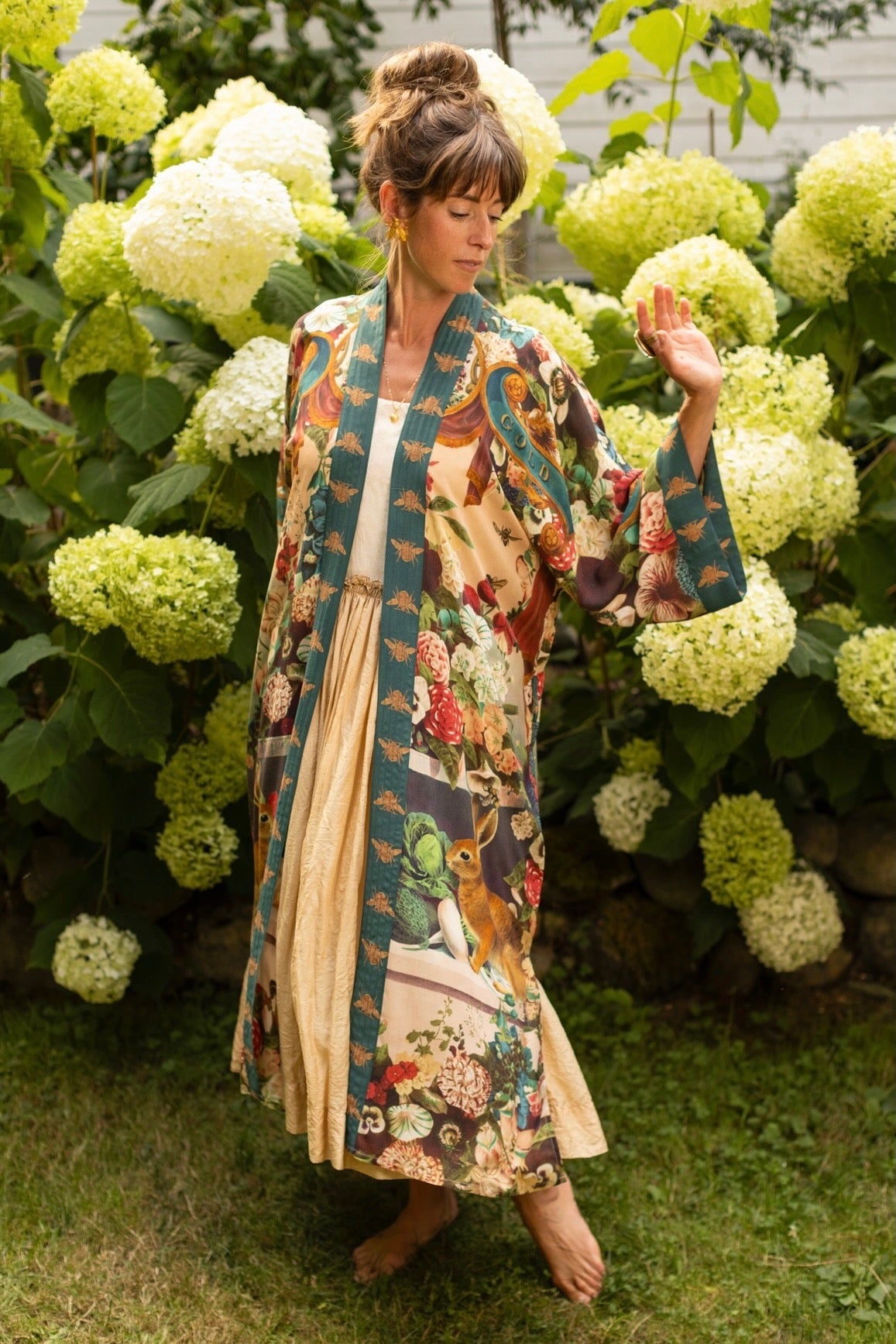 Model wearing Stay Gold Opera Duster with wildflower, bee, and bunny rabbit illustrations, golden script, and vintage collage in full-length kimono silhouette – Market of Stars