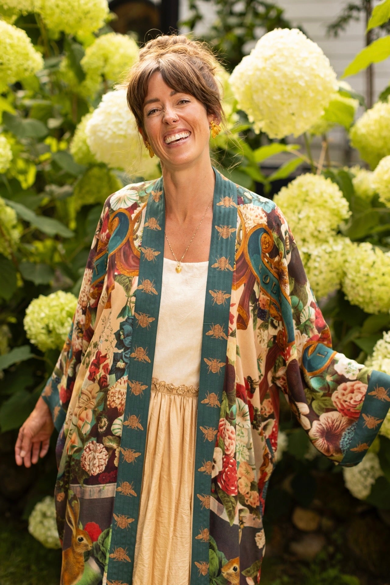 Model wearing Stay Gold Opera Duster with wildflower, bee, and bunny rabbit illustrations, golden script, and vintage collage in full-length kimono silhouette – Market of Stars