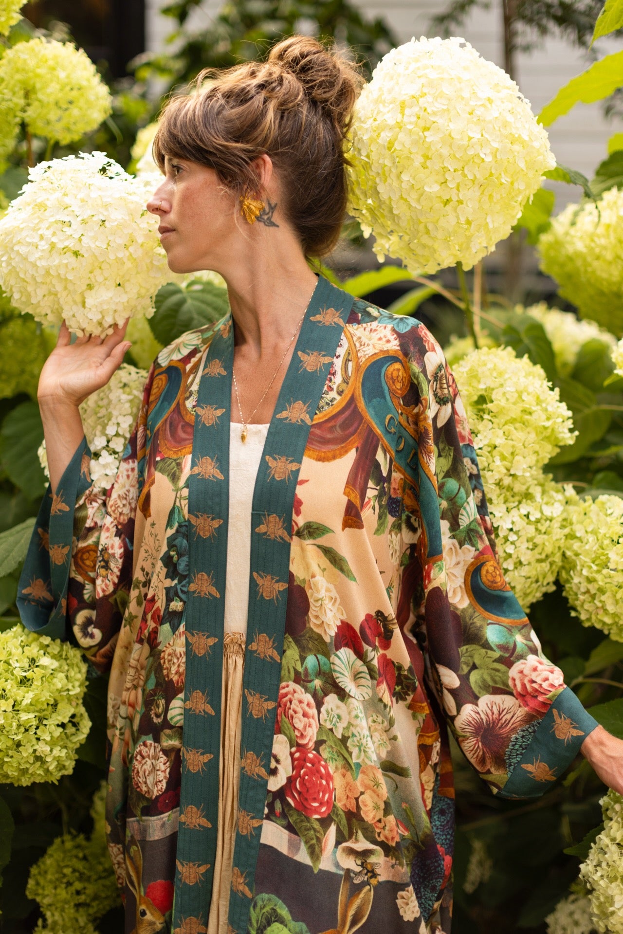 Model wearing Stay Gold Opera Duster with wildflower, bee, and bunny rabbit illustrations, golden script, and vintage collage in full-length kimono silhouette – Market of Stars