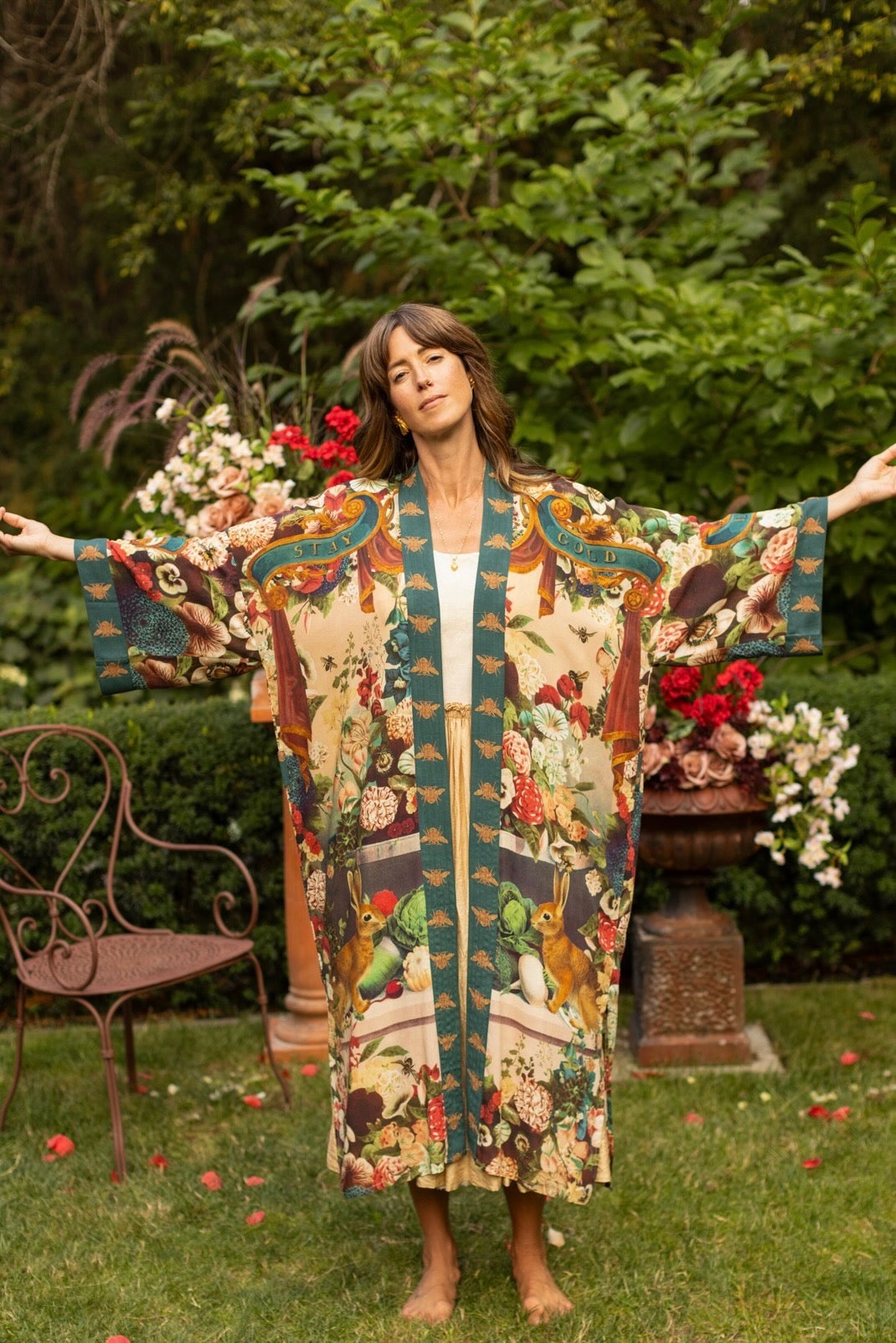 Model wearing Stay Gold Opera Duster with wildflower, bee, and bunny rabbit illustrations, golden script, and vintage collage in full-length kimono silhouette – Market of Stars