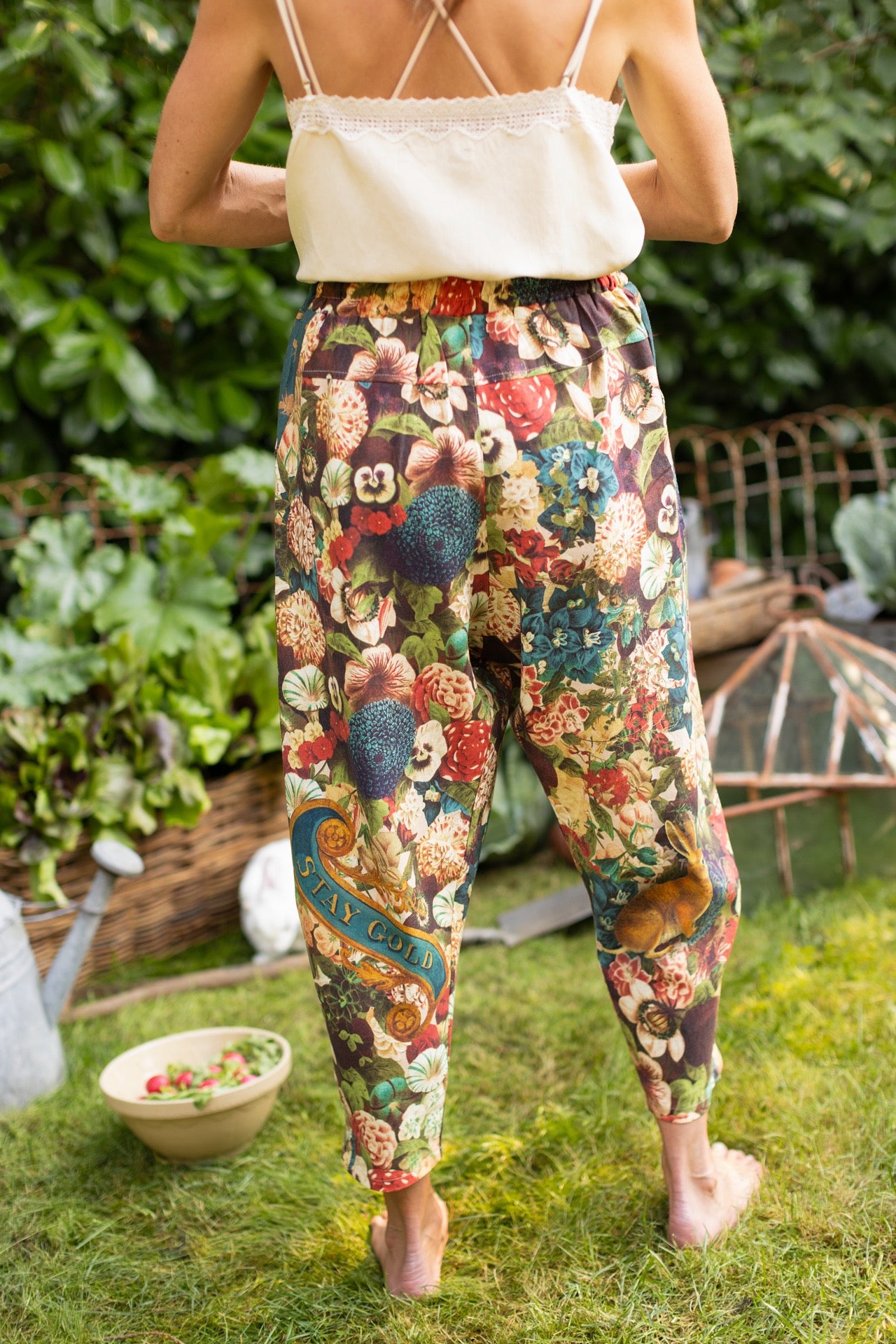 Model wearing Stay Gold linen Artist Pants with lantern hem and floral collage featuring vintage wildflower, bee, and rabbit illustrations – Market of Stars