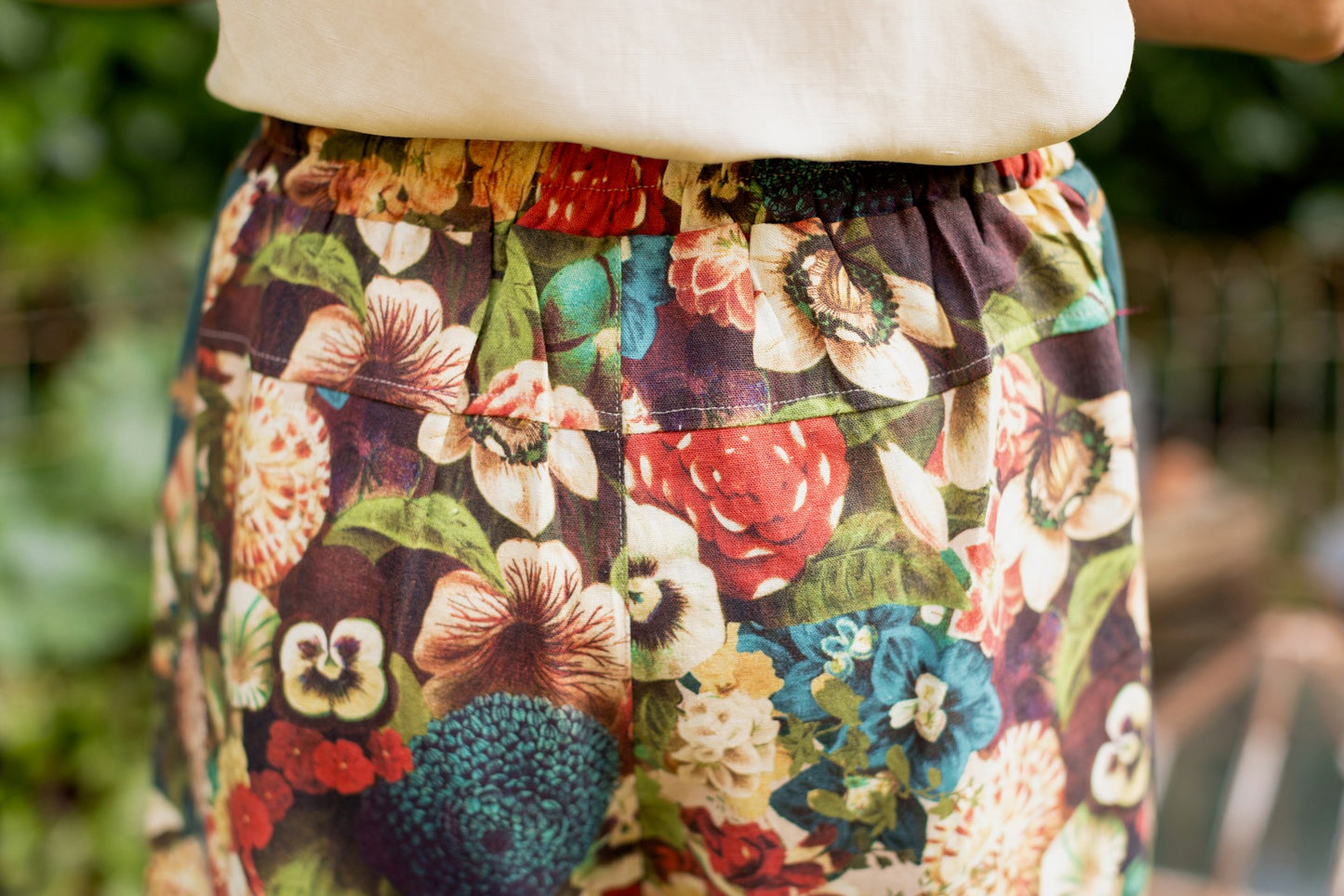 Model wearing Stay Gold linen Artist Pants with lantern hem and floral collage featuring vintage wildflower, bee, and rabbit illustrations – Market of Stars