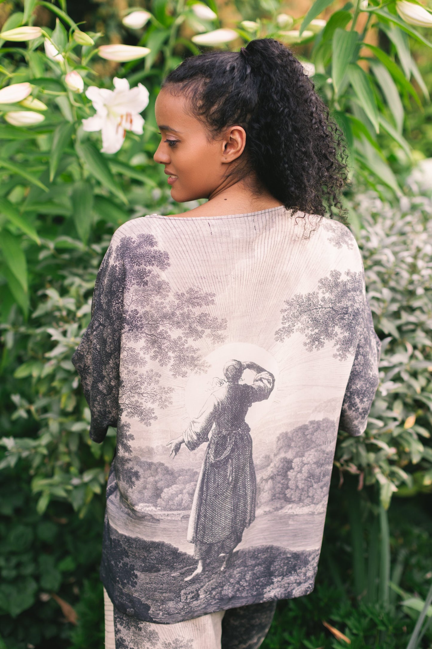Model wearing the Still I Rise Luxe Tee with wide scoop neck and soft bamboo-based viscose, featuring vintage landscape etching and an inspiring message – Market of Stars