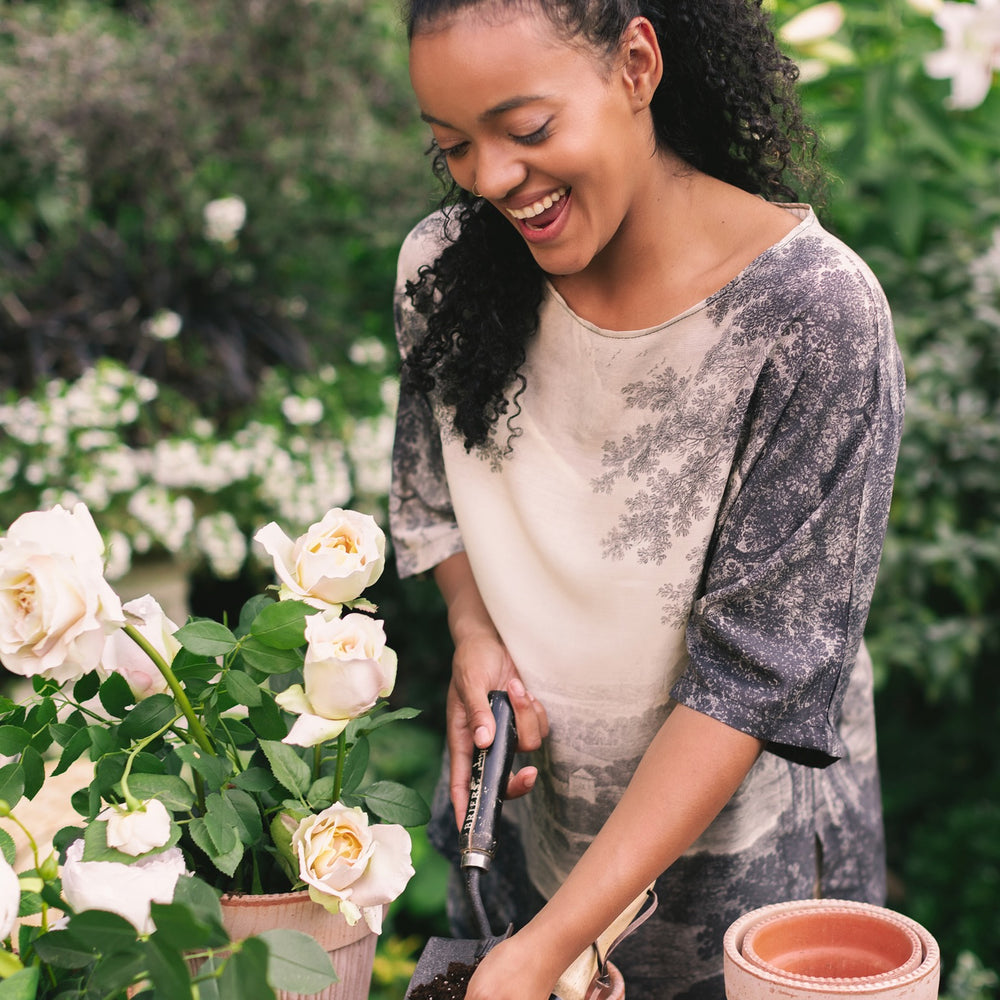 Model wearing the Still I Rise Luxe Tee with wide scoop neck and soft bamboo-based viscose, featuring vintage landscape etching and an inspiring message – Market of Stars