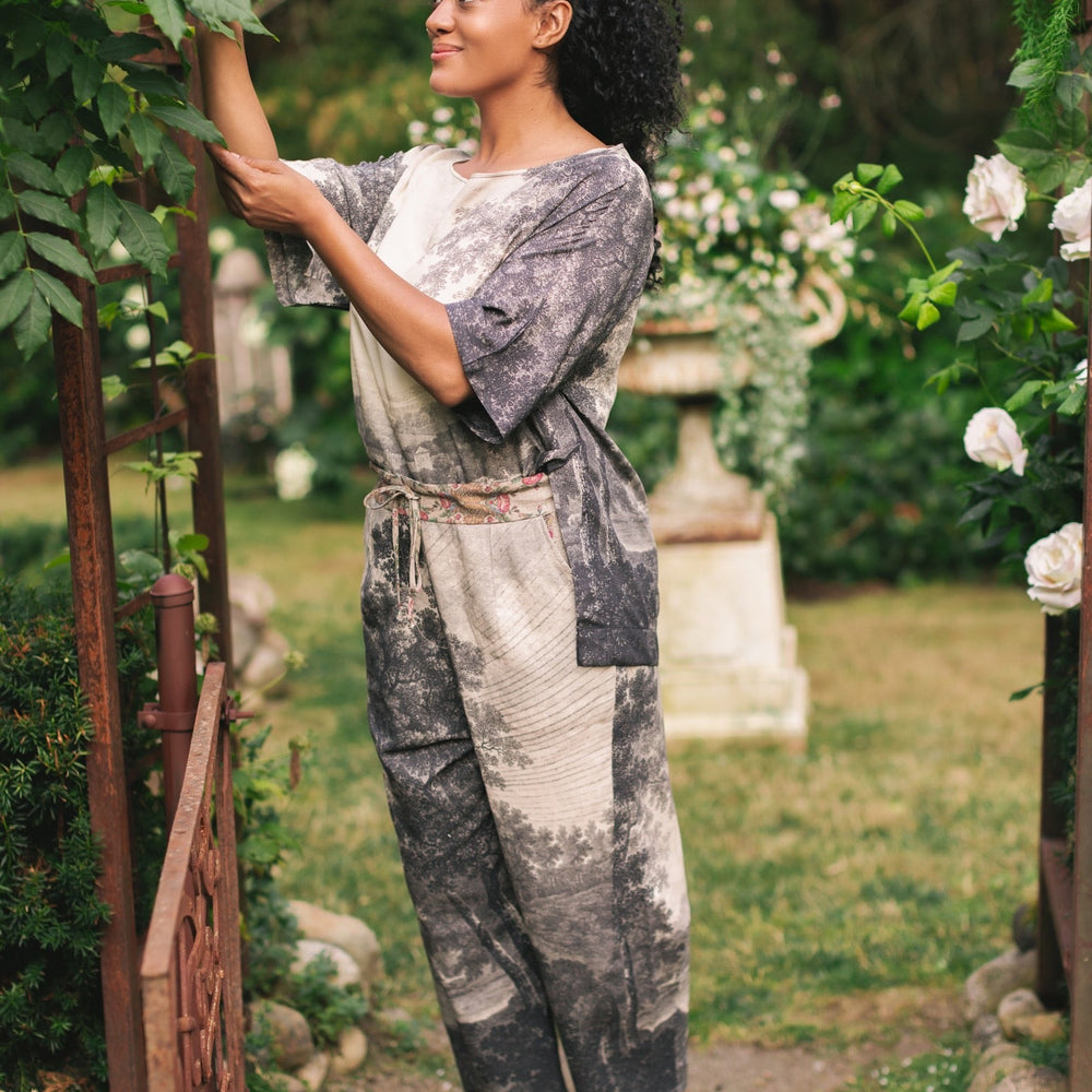 
                  
                    Model wearing the Still I Rise Luxe Tee with wide scoop neck and soft bamboo-based viscose, featuring vintage landscape etching and an inspiring message – Market of Stars
                  
                