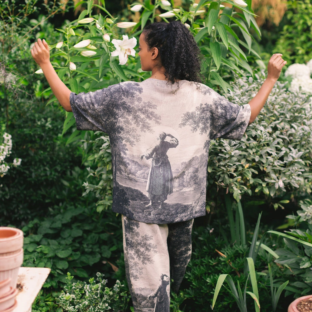 
                  
                    Model wearing the Still I Rise Luxe Tee with wide scoop neck and soft bamboo-based viscose, featuring vintage landscape etching and an inspiring message – Market of Stars
                  
                