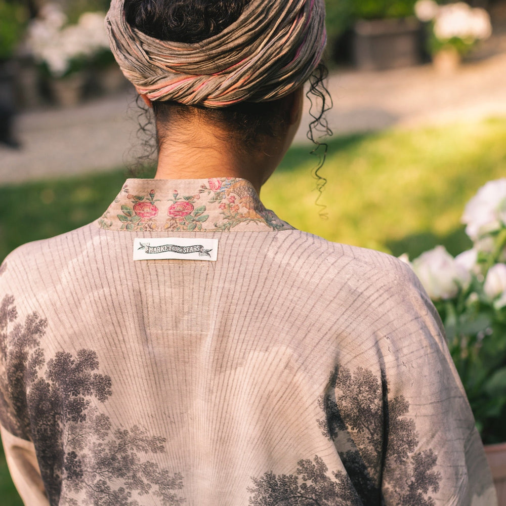 
                  
                    Model wearing our Still I Rise Pixie Duster with empowering message a bold, layered design featuring antique landscape etchings – Market of Stars
                  
                