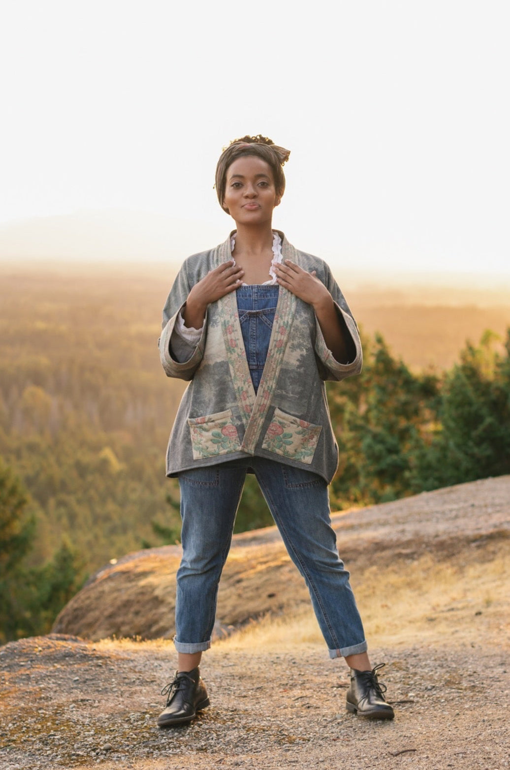 Model wearing the Still I Rise Cottage Cardigan featuring a soft fleece lining and antique landscape etchings in a design inspired by rising strength – Market of Stars
