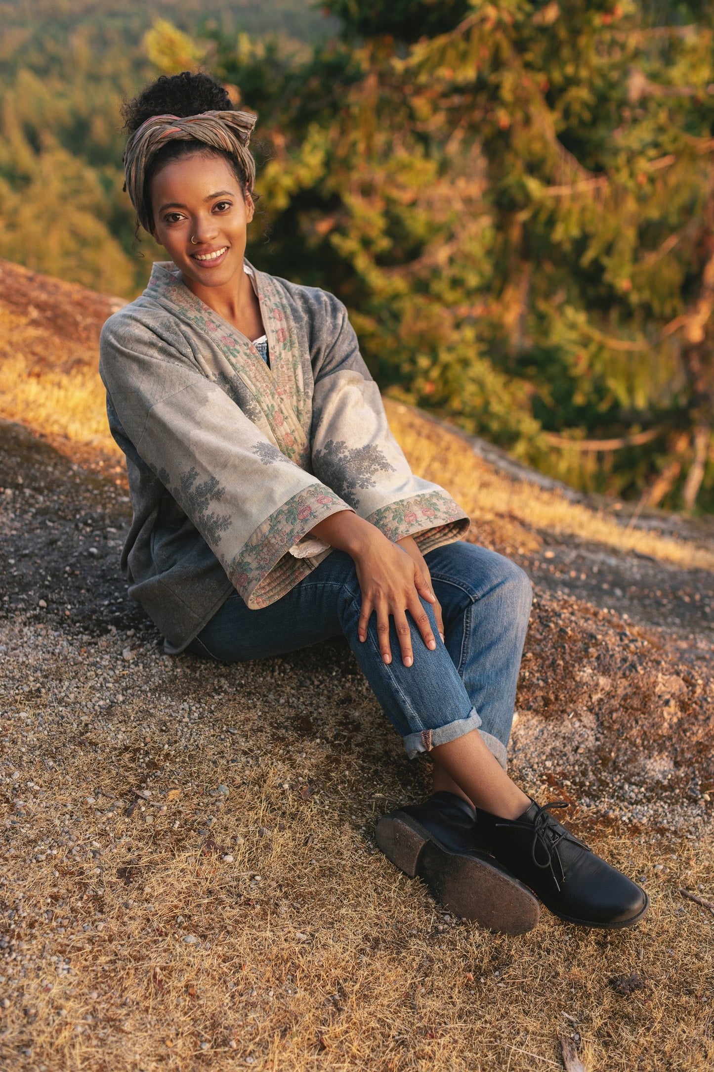 Model wearing the Still I Rise Cottage Cardigan featuring a soft fleece lining and antique landscape etchings in a design inspired by rising strength – Market of Stars