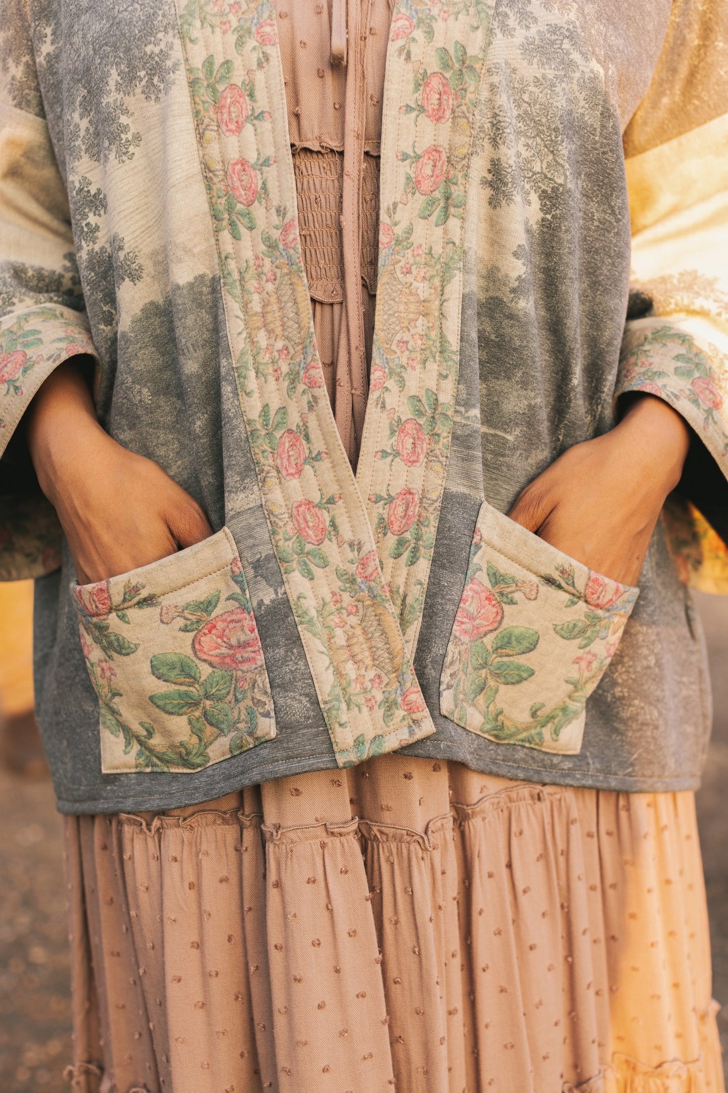 Model wearing the Still I Rise Cottage Cardigan featuring a soft fleece lining and antique landscape etchings in a design inspired by rising strength – Market of Stars
