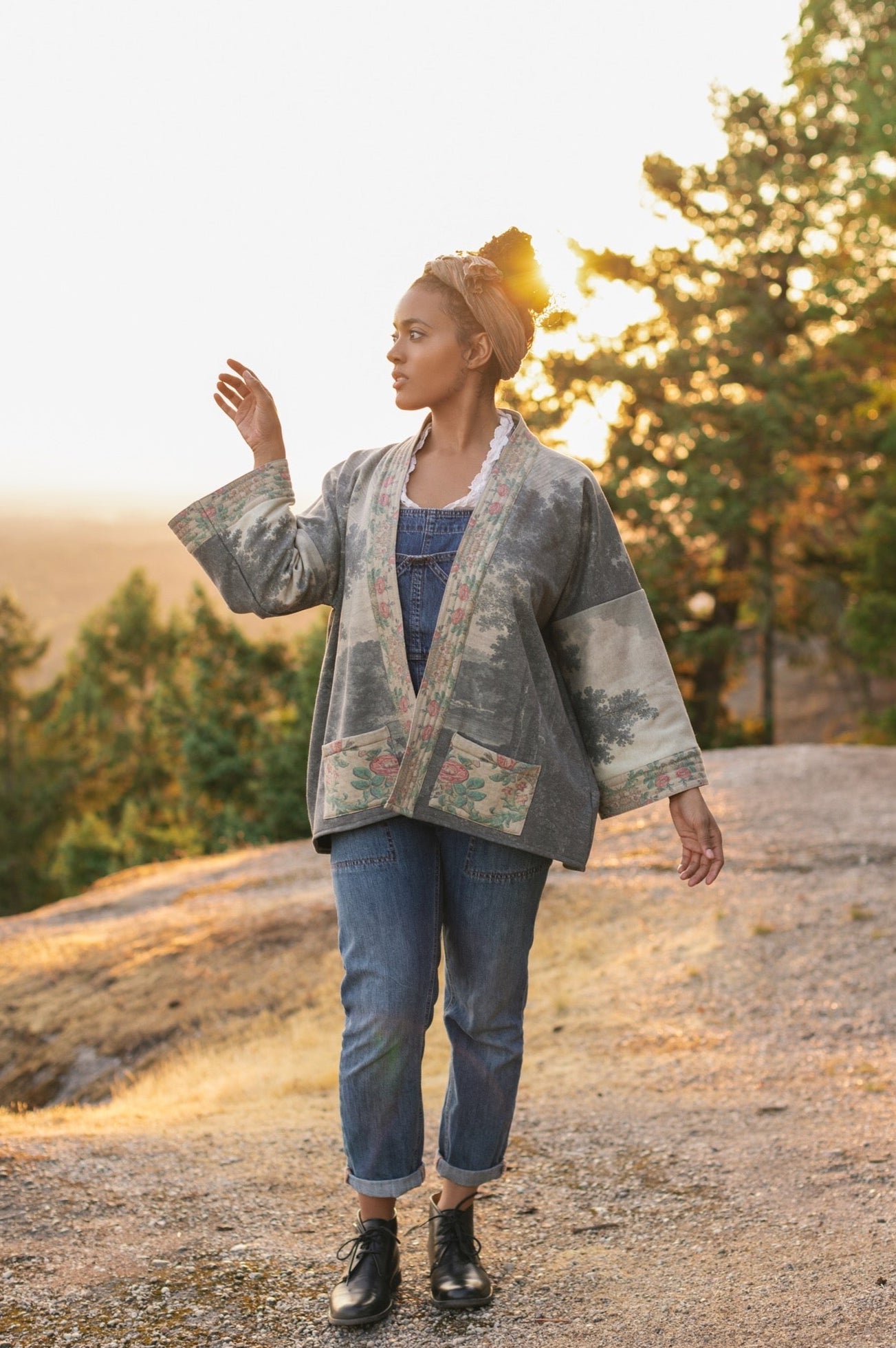 Model wearing the Still I Rise Cottage Cardigan featuring a soft fleece lining and antique landscape etchings in a design inspired by rising strength – Market of Stars