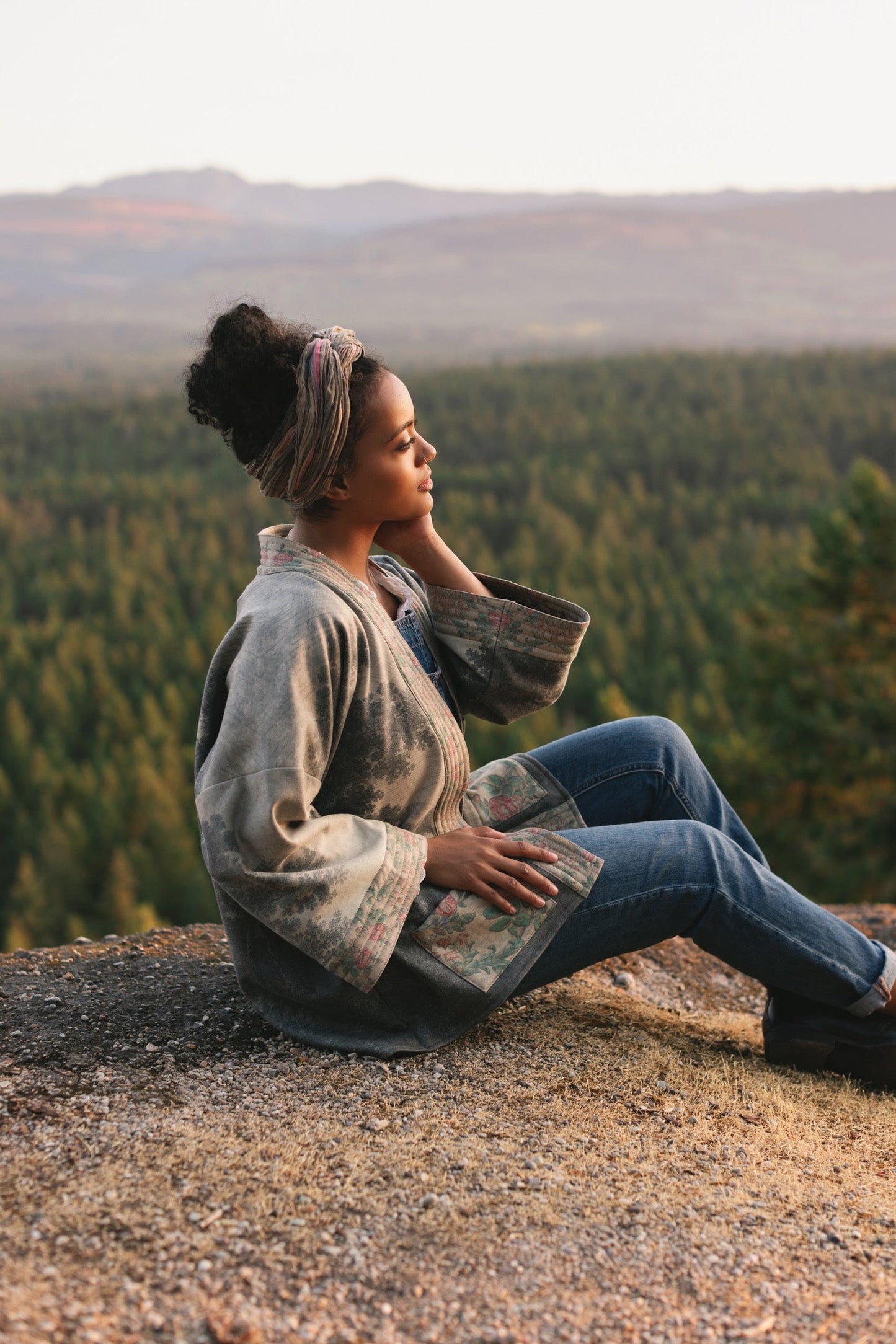 Model wearing the Still I Rise Cottage Cardigan featuring a soft fleece lining and antique landscape etchings in a design inspired by rising strength – Market of Stars