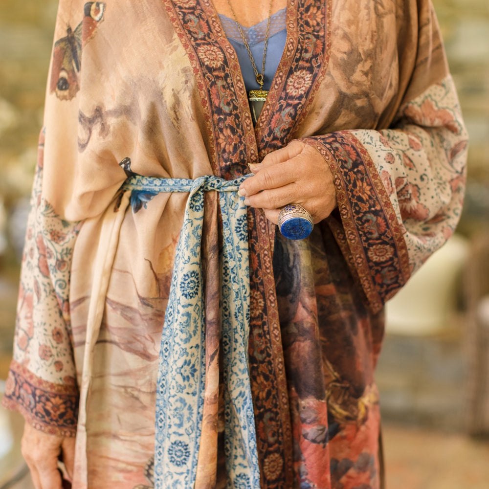 
                  
                    Model(s) wearing The Storyteller -- a mid-length Matinée kimono duster featuring antique artwork and vintage prints from around the world -- Market of Stars
                  
                