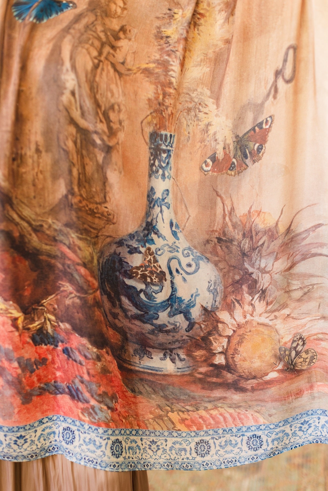 Model wearing lightweight Storyteller scarf, featuring antique watercolour artwork and a mixture of prints from around the world -- Market of Stars