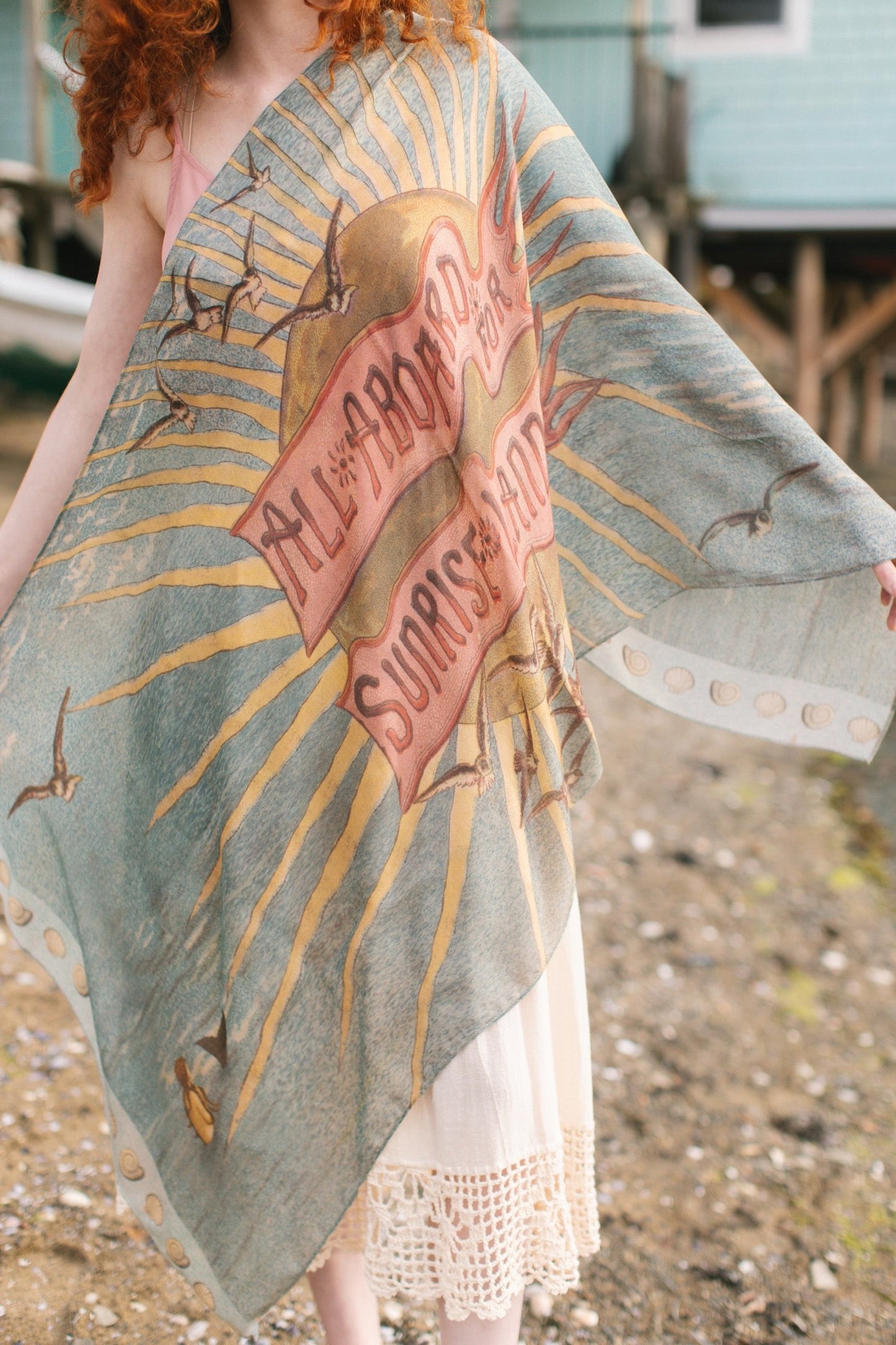 Lightweight scarf featuring a dreamy sunrise landscape and nautical artwork with the words 